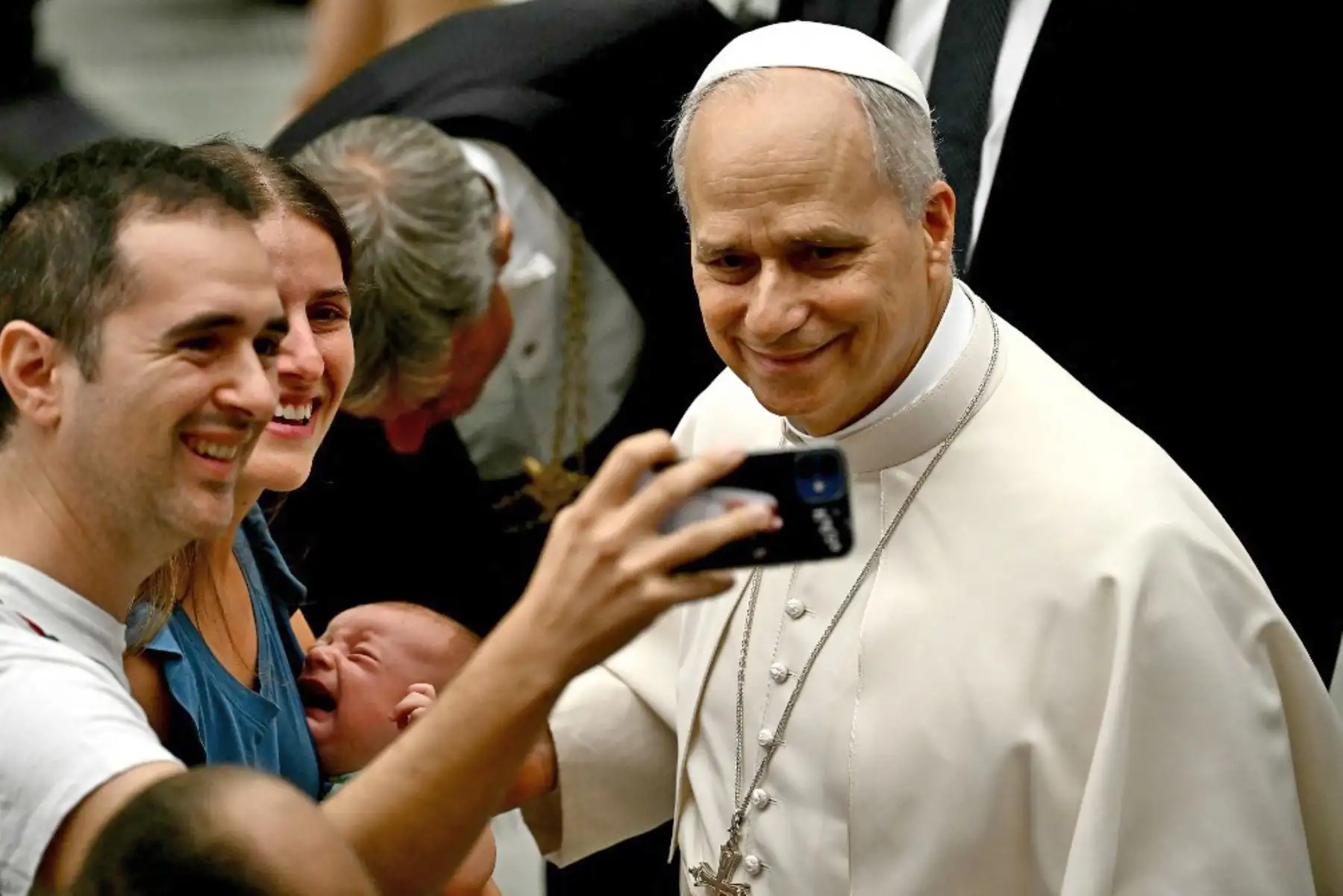El Papa León XIV posa para una selfie con una familia durante la audiencia general en el Aula Pablo VI del Vaticano. Foto: AFP