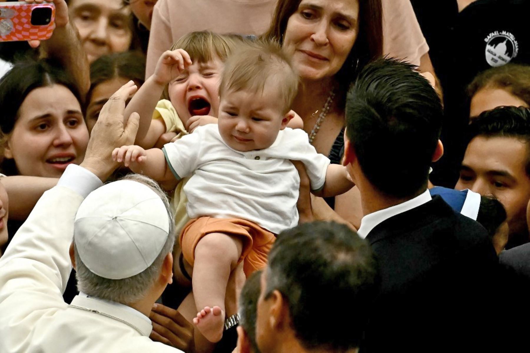 El Papa León XIV bendice a una familia durante la audiencia general en el Aula Pablo VI del Vaticano. Foto: AFP