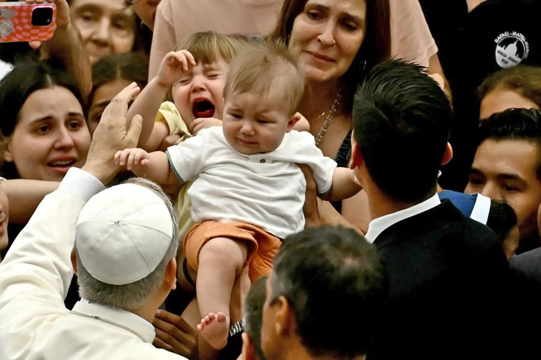 El Papa León XIV bendice a una familia durante la audiencia general en el Aula Pablo VI del Vaticano. Foto: AFP