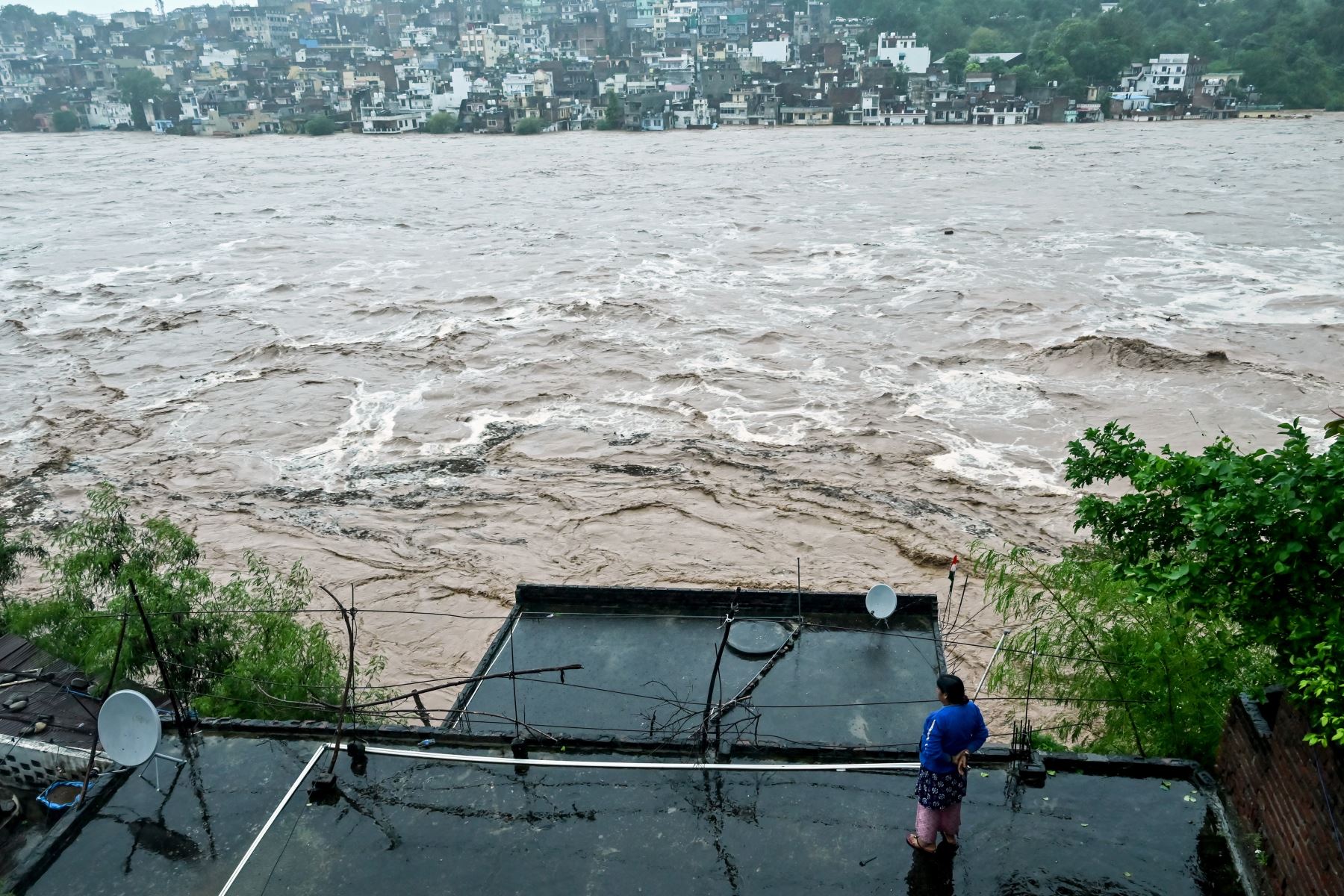 Una mujer local observa el desbordamiento del río Tawi después de que fuertes lluvias provocaran un aumento en su nivel de agua en Jammu.
Foto: AFP
