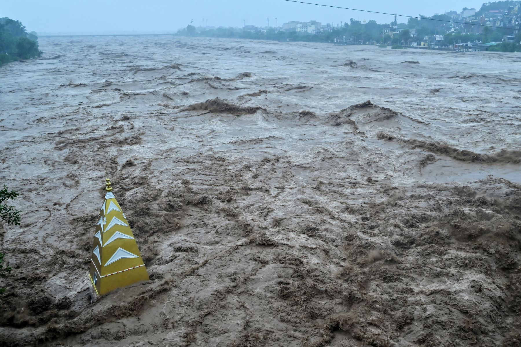 Un torrente de agua se estrella contra un templo hindú parcialmente sumergido en las aguas de la inundación después de que fuertes lluvias provocaran un aumento en el nivel del agua del río Tawi en Jammu .
Foto: AFP