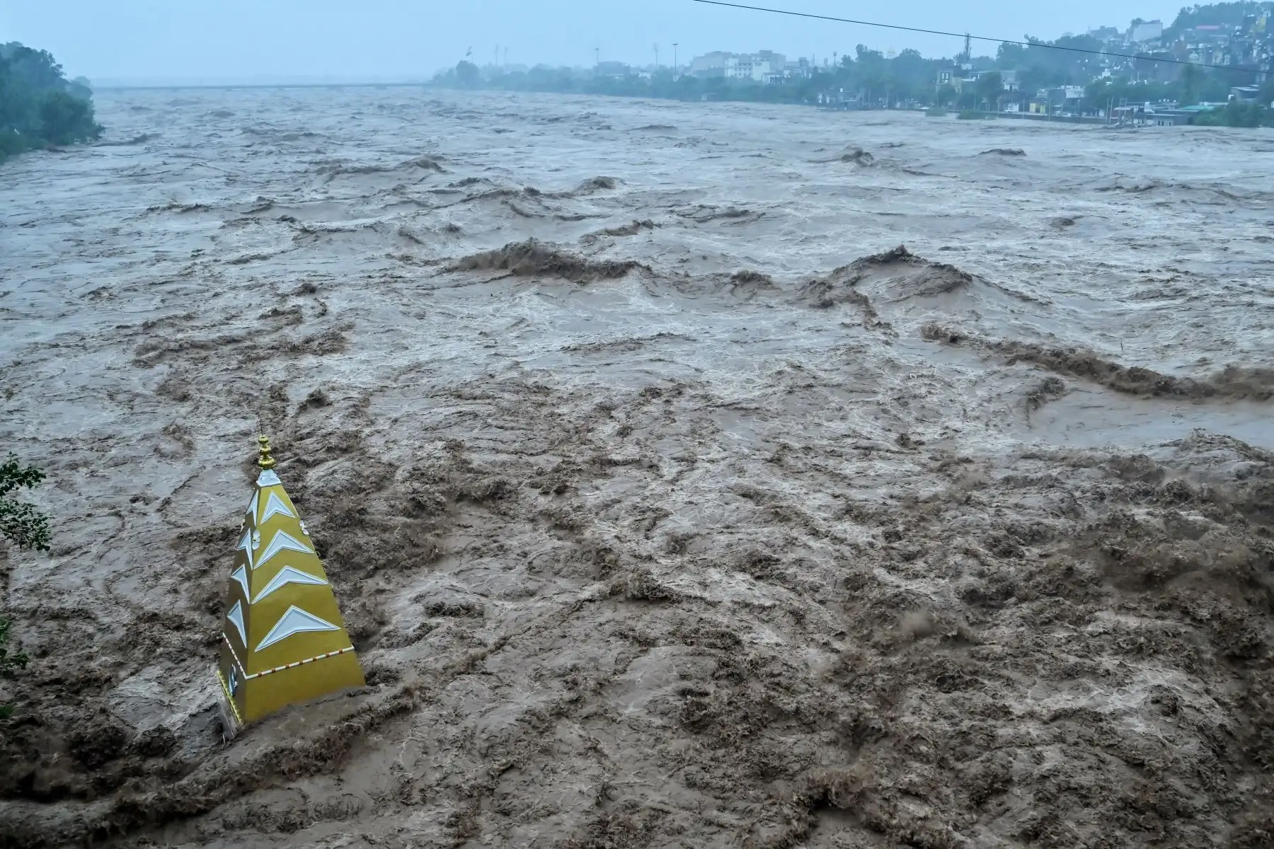 Un torrente de agua se estrella contra un templo hindú parcialmente sumergido en las aguas de la inundación después de que fuertes lluvias provocaran un aumento en el nivel del agua del río Tawi en Jammu .
Foto: AFP