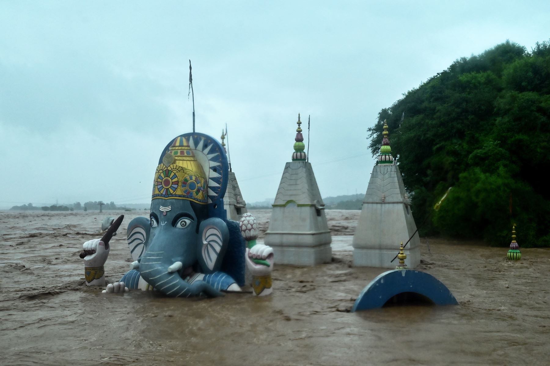 Un templo hindú se encuentra parcialmente sumergido en las aguas de la inundación después de que fuertes lluvias provocaran un aumento en el nivel del agua del río Tawi en Jammu.
Foto: AFP