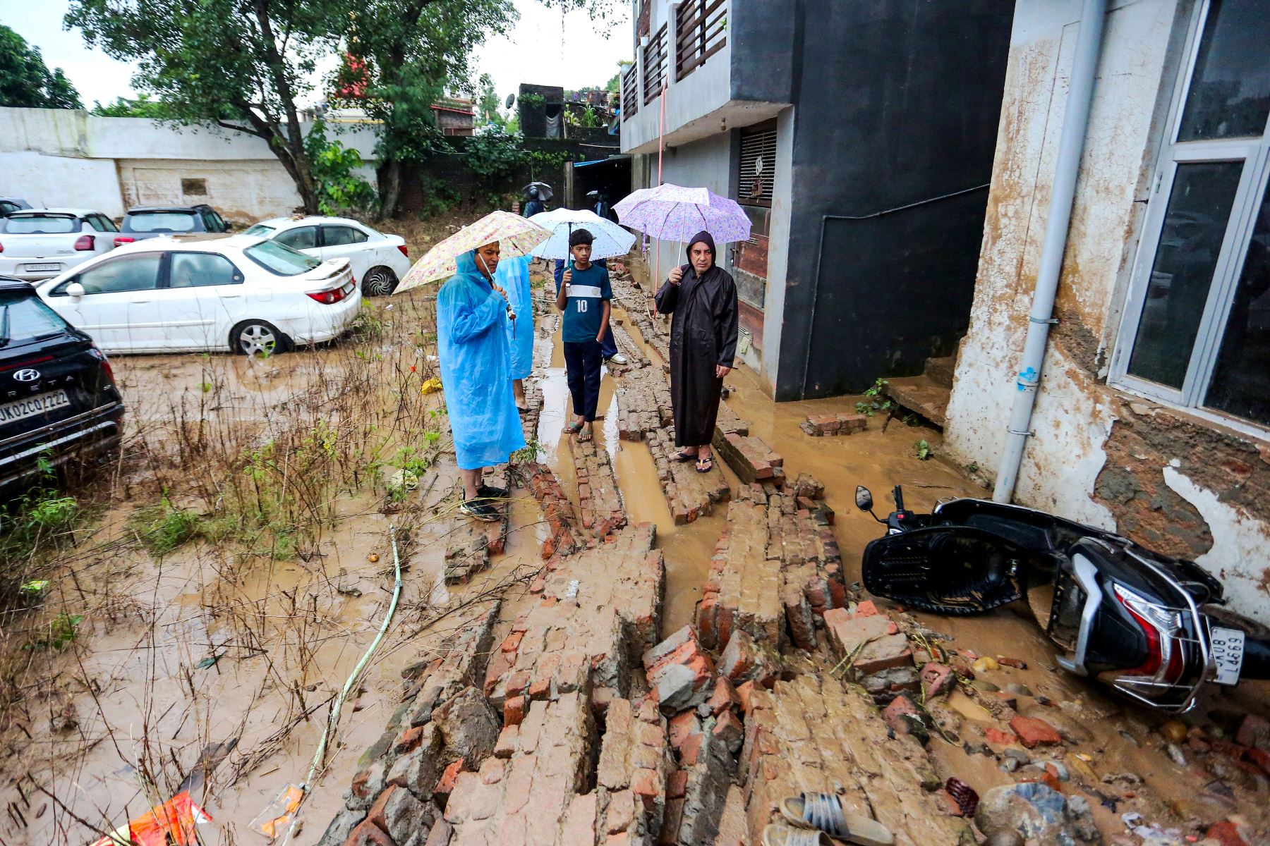 Hombres locales miran un scooter dañado en una zona residencial inundada de lodo después de que fuertes lluvias provocaran inundaciones repentinas en Jammu.
Foto: AFP