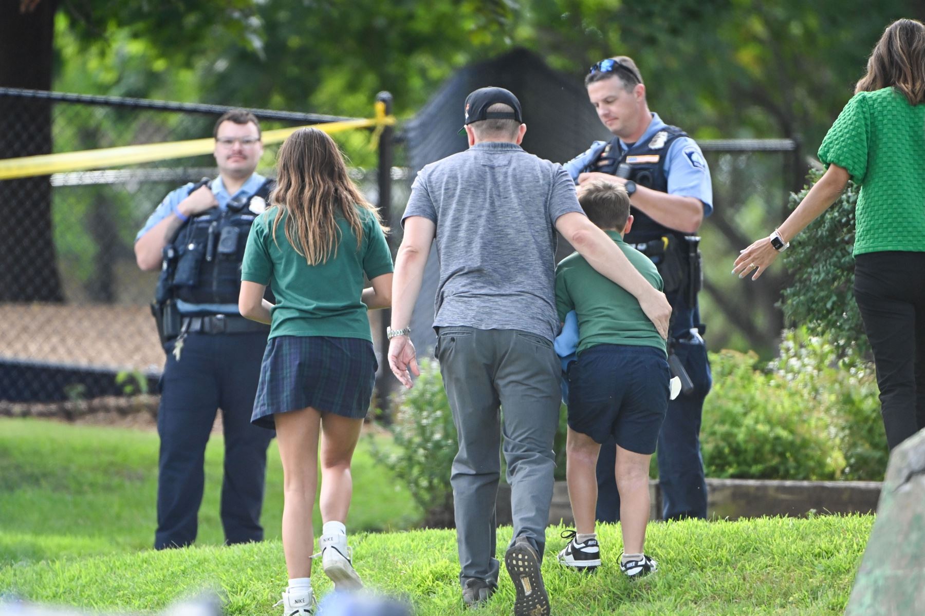 Un adulto y un niño salen de la escuela mientras la policía responde a un tiroteo en la Escuela Católica Annunciation en Minneapolis, Minnesota, EE. UU., el 27 de agosto de 2025. Según la policía, dos niños y el pistolero murieron y varios resultaron heridos en el tiroteo en una iglesia católica. Foto: EFE
