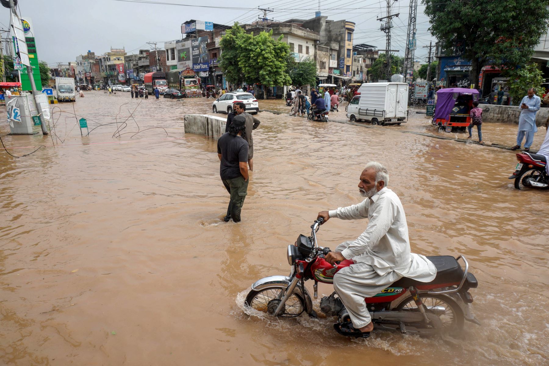 Un viajero diario conduce su motocicleta por una carretera inundada en la zona de Wazirabad, ciudad de la provincia de Punjab. Foto: AFP