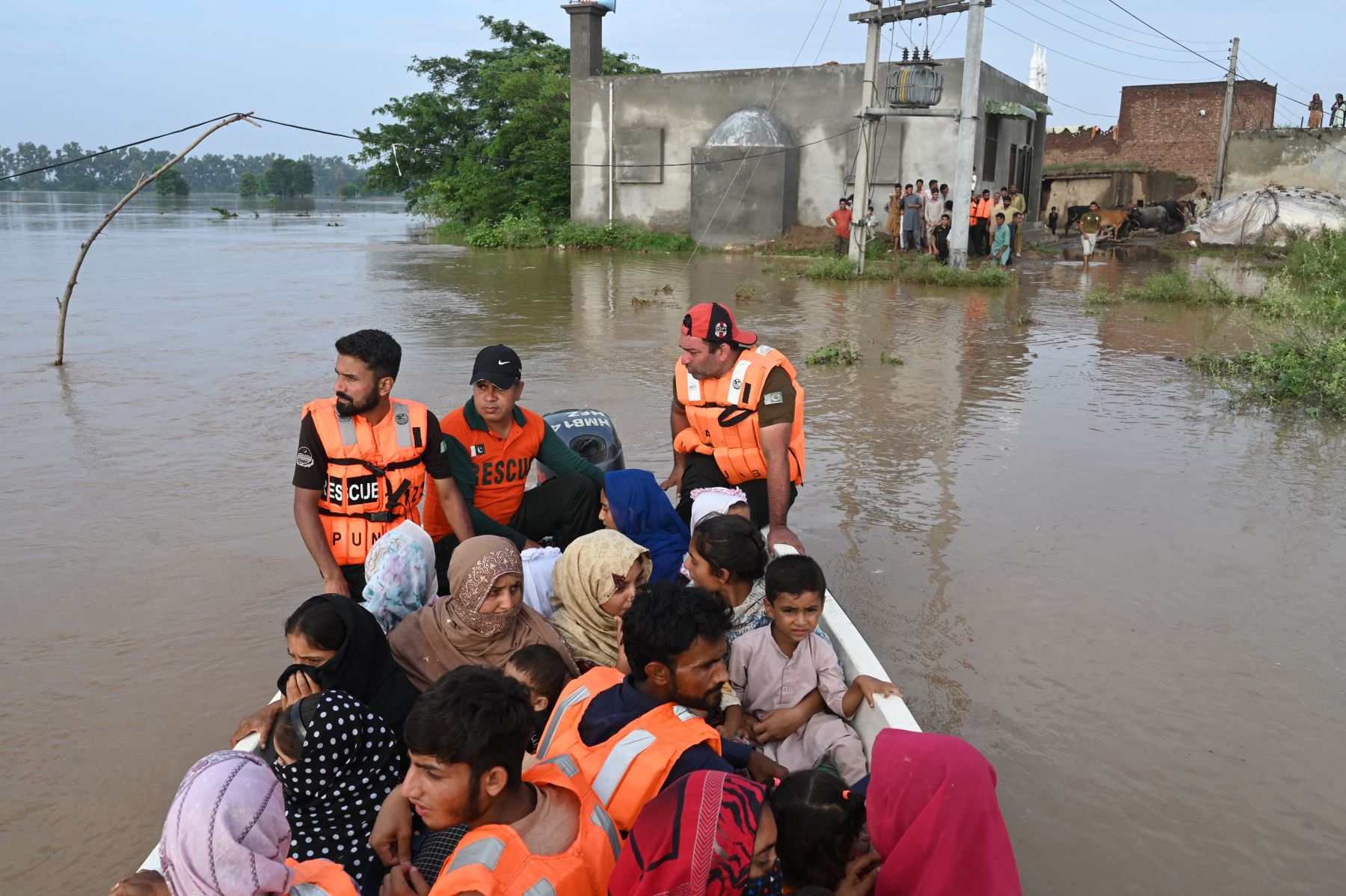 Los rescatistas en una pequeña embarcación transportan a residentes de la zona inundada de Narowal, una ciudad de la provincia de Punjab. AFP