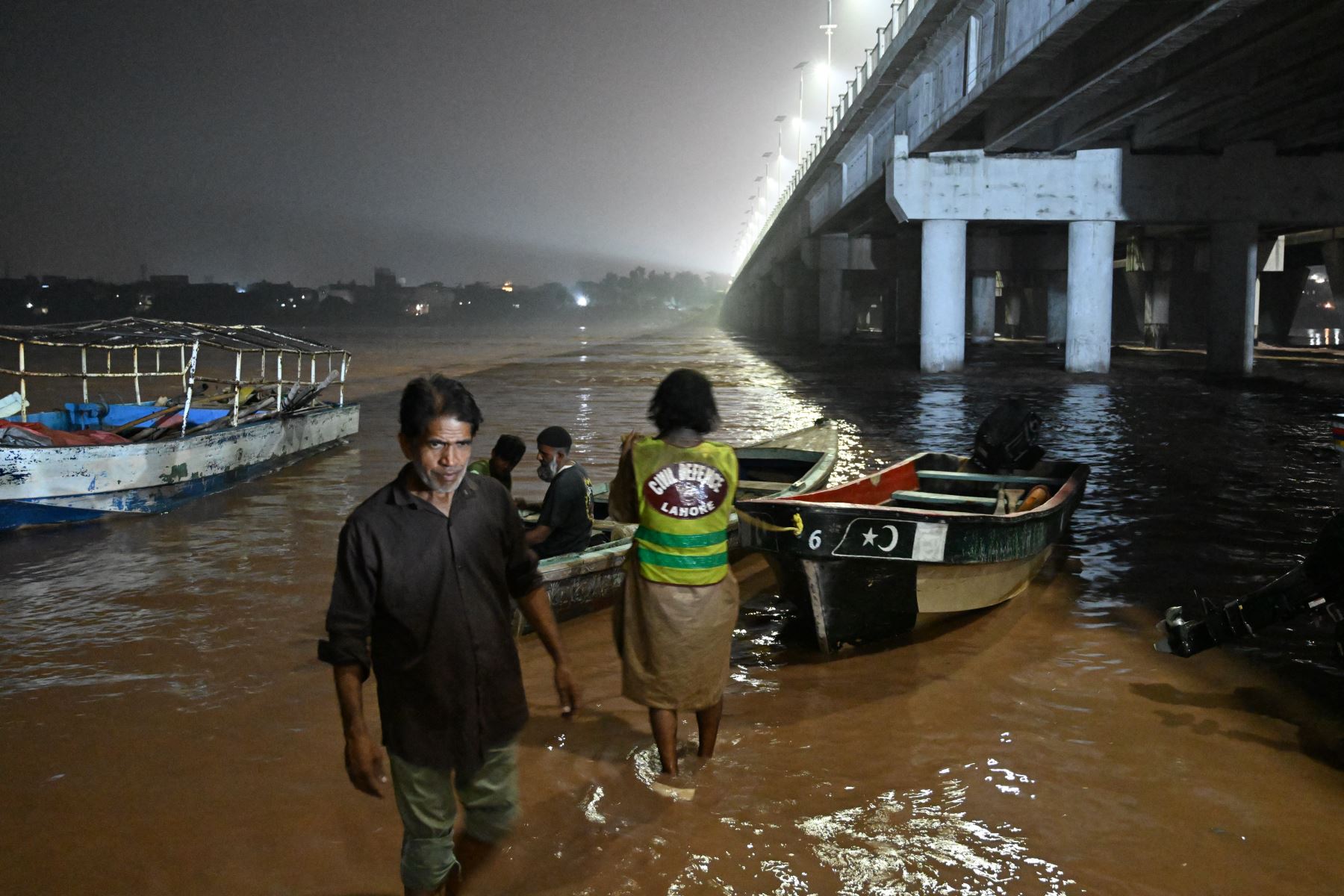 Miembros de la Defensa Civil preparan sus embarcaciones a lo largo de la orilla del río Ravi tras la crecida que afectó la zona de Shahdara, mientras el gobierno emitía una alerta de inundación para las zonas ribereñas de la provincia de Punjab, en Lahore. AFP