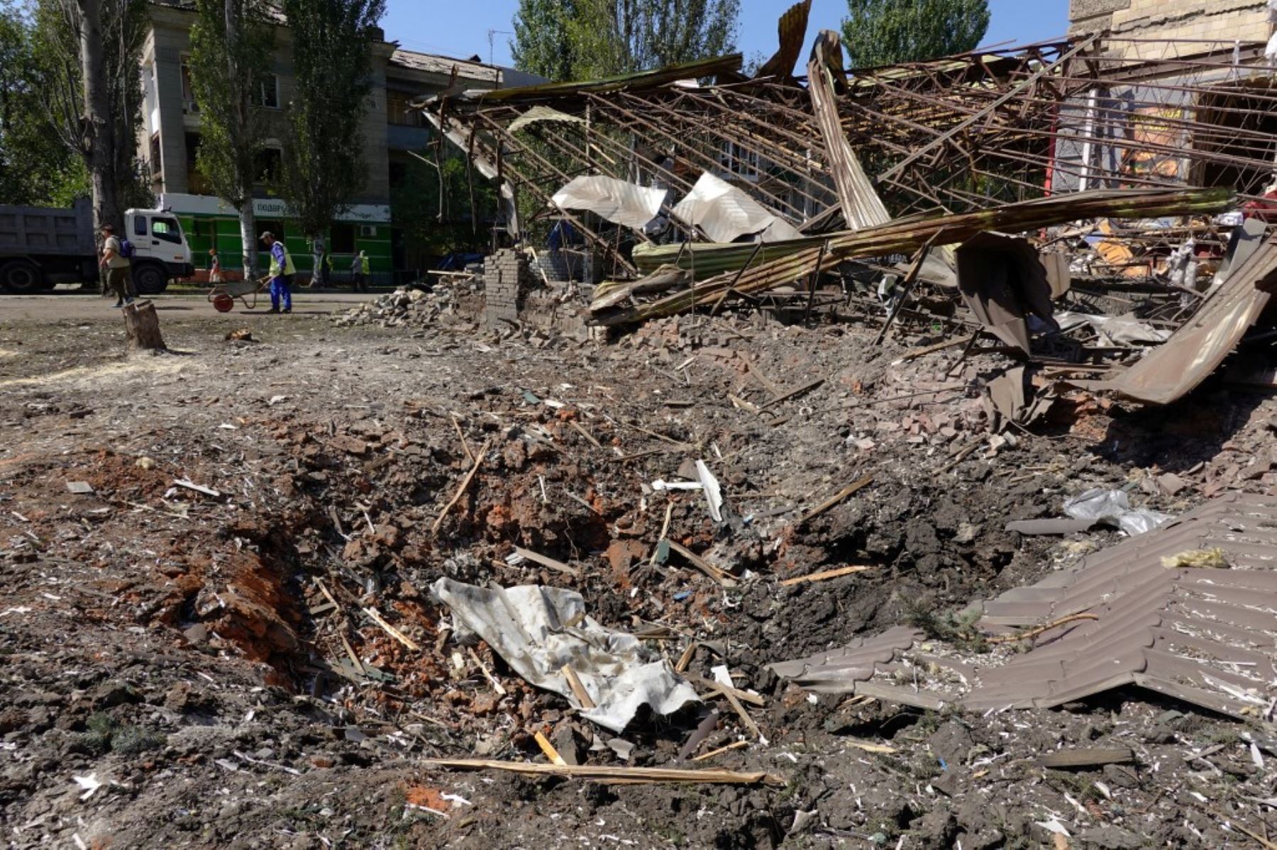Trabajadores municipales limpian una calle junto a un edificio dañado tras un ataque con misiles rusos en Sloviansk el 28 de agosto de 2025, en medio de la invasión rusa de Ucrania. Foto: AFP