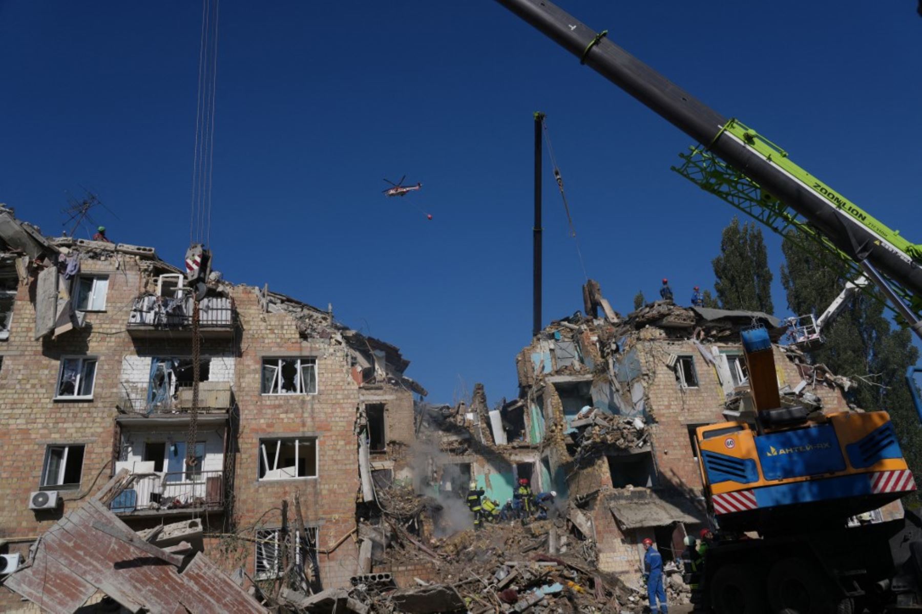 Un helicóptero de extinción de incendios sobrevuela un edificio residencial gravemente dañado tras un ataque a gran escala con drones y misiles rusos contra Kiev el 28 de agosto de 2025, en medio de la invasión rusa de Ucrania. Foto: AFP