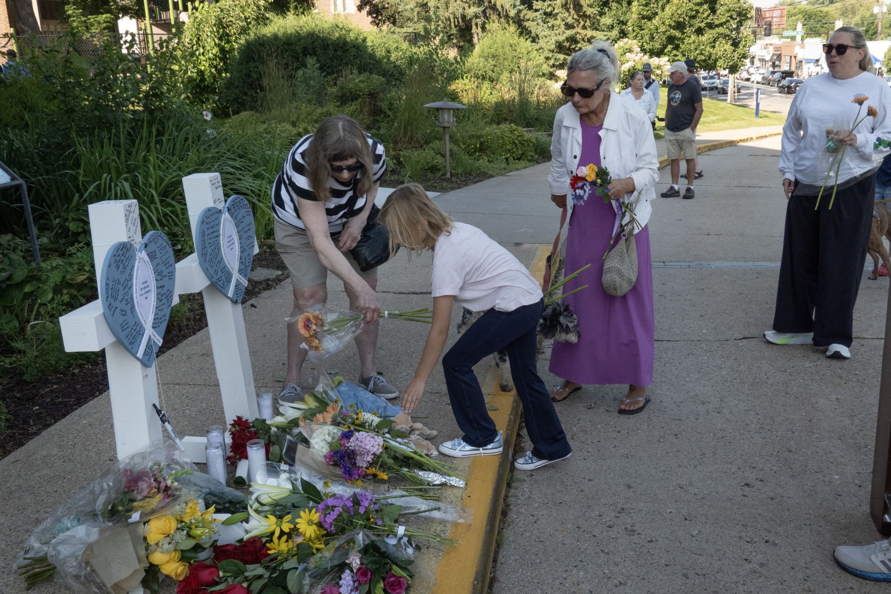 La gente visita un monumento conmemorativo a las víctimas del tiroteo de ayer frente a la Iglesia Católica de la Anunciación  en Minneapolis, Minnesota. AFP