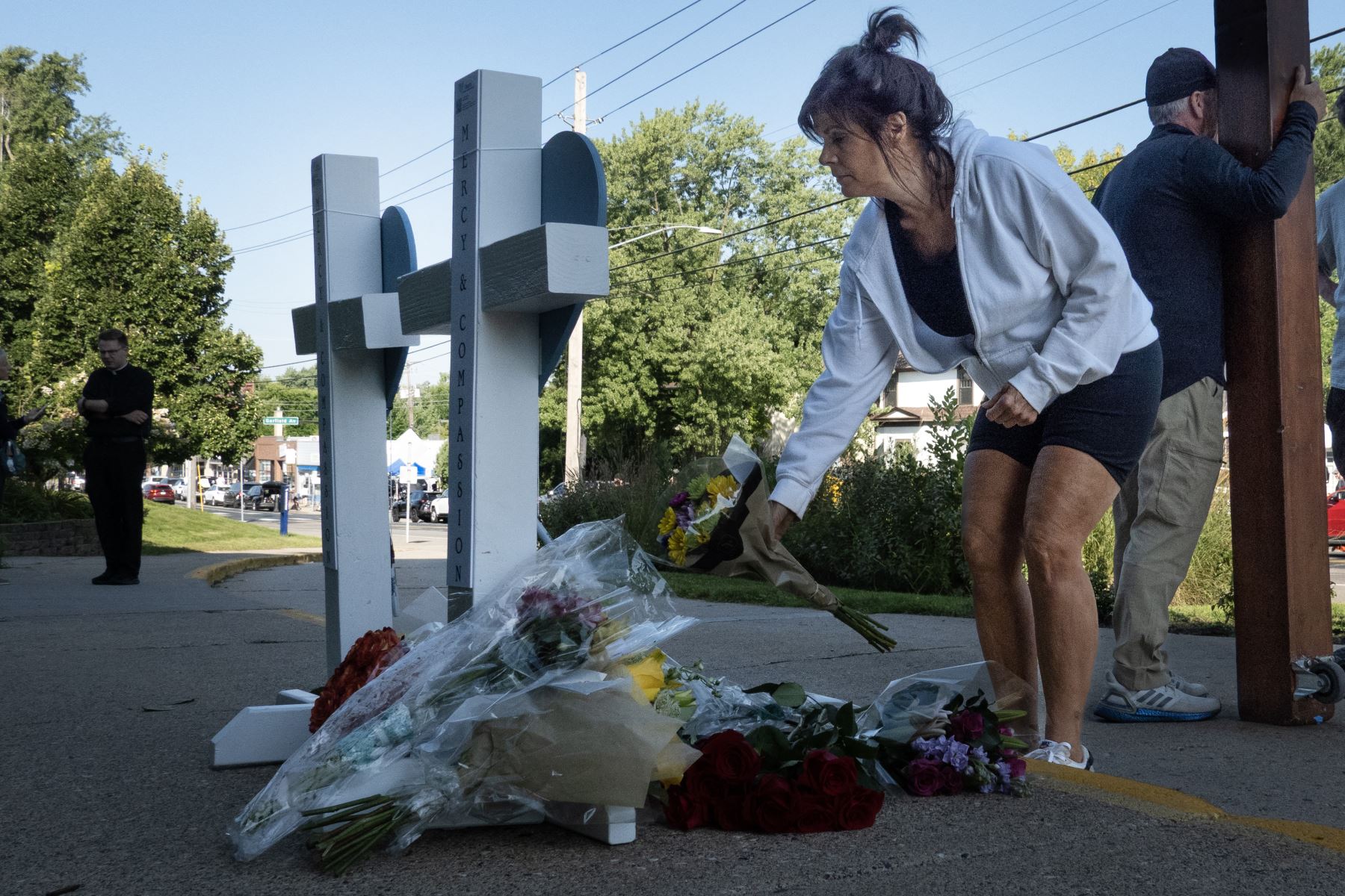 La gente visita un monumento conmemorativo a las víctimas del tiroteo de ayer frente a la Iglesia Católica de la Anunciación  en Minneapolis, Minnesota. AFP