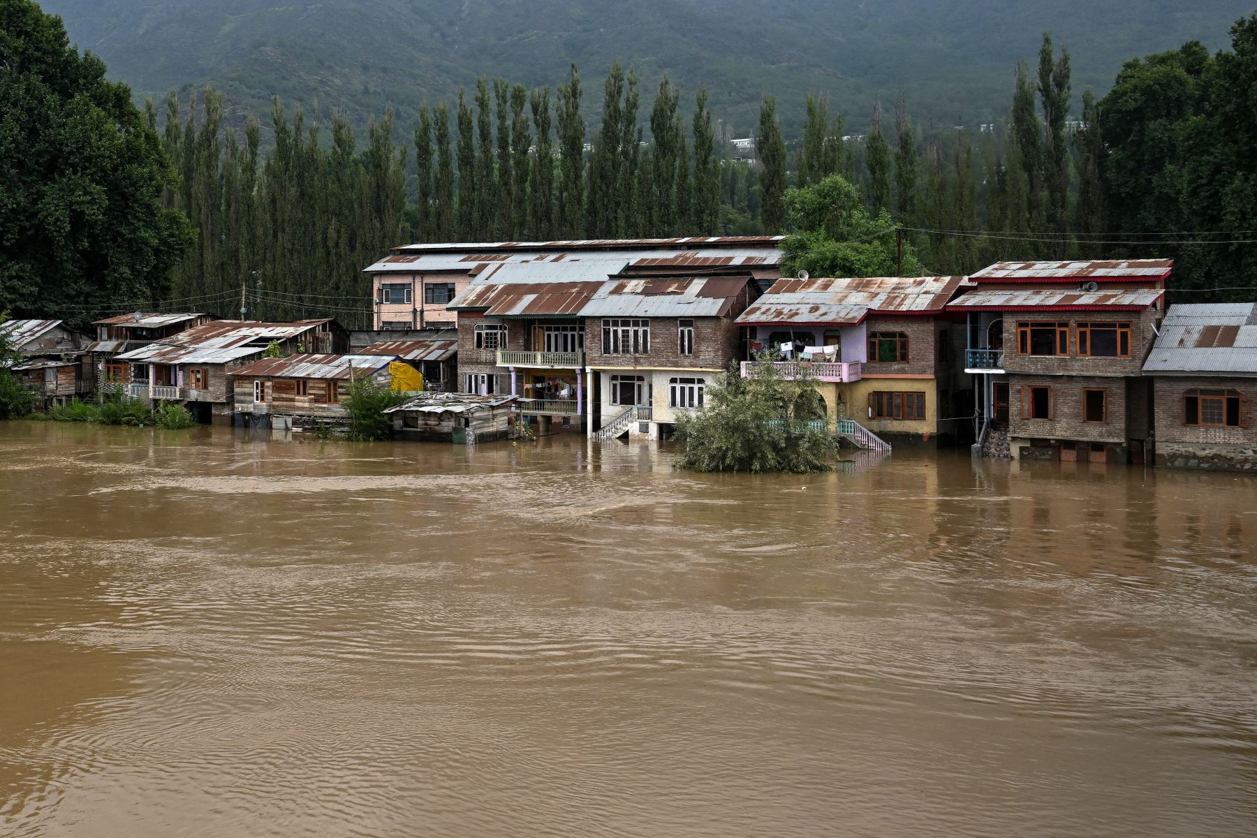 Se muestran casas parcialmente sumergidas a lo largo de las orillas del río Jhelum después de las fuertes lluvias en Srinagar. AFP