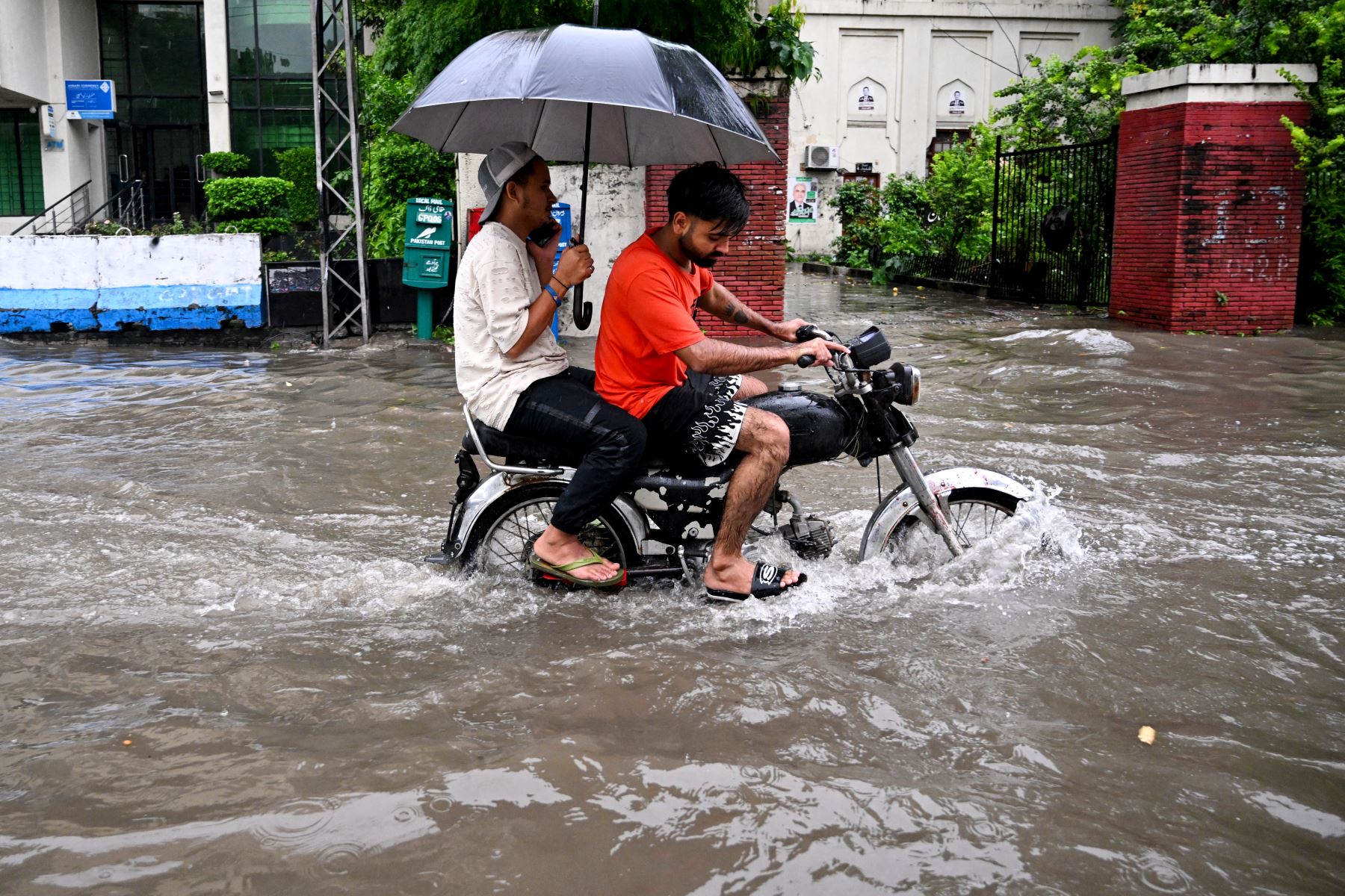 Los viajeros circulan por una carretera inundada en medio de fuertes lluvias en Lahore.
Foto: AFP