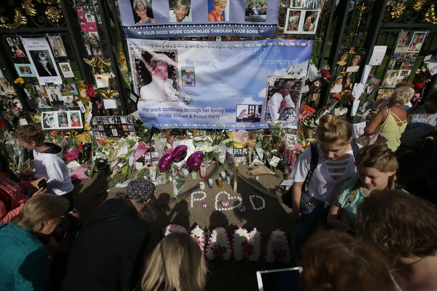 El público se reunió para recibir ofrendas florales, velas y fotografías frente a una de las puertas del Palacio de Kensington en Londres el 31 de agosto de 2017, para conmemorar el 20.º aniversario del fallecimiento de Diana, Princesa de Gales.  Foto: ANDINA/ AFP