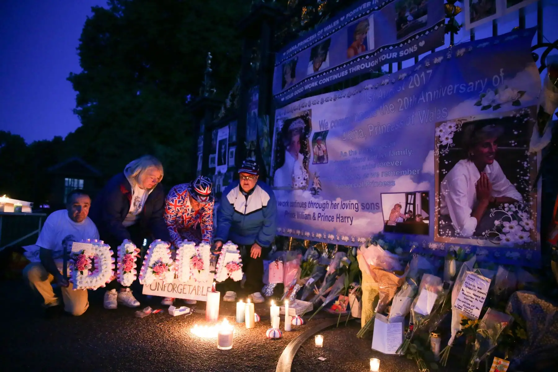 Fans de la realeza, incluyendo a John Loughry (izq.), ofrecieron su propio homenaje con flores, velas y fotografías en una de las entradas del Palacio de Kensington en Londres, la madrugada del 31 de agosto de 2017, para conmemorar el 20.º aniversario del fallecimiento de Diana, Princesa de Gales. Foto: ANDINA/ AFP