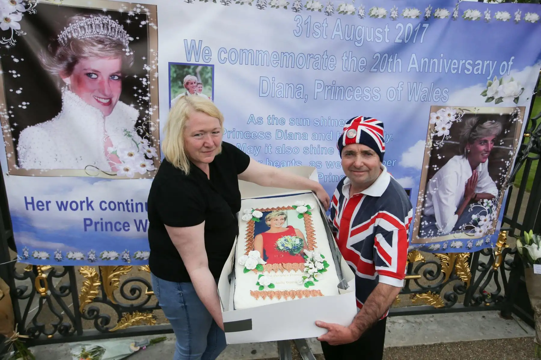 Los admiradores de la realeza, John Loughrey y Maria Scott, posan con un pastel adornado con una imagen de Diana, Princesa de Gales, frente a una de las entradas del Palacio de Kensington, donde se ofrecen ofrendas florales y fotografías en el centro de Londres. Foto: ANDINA/AFP