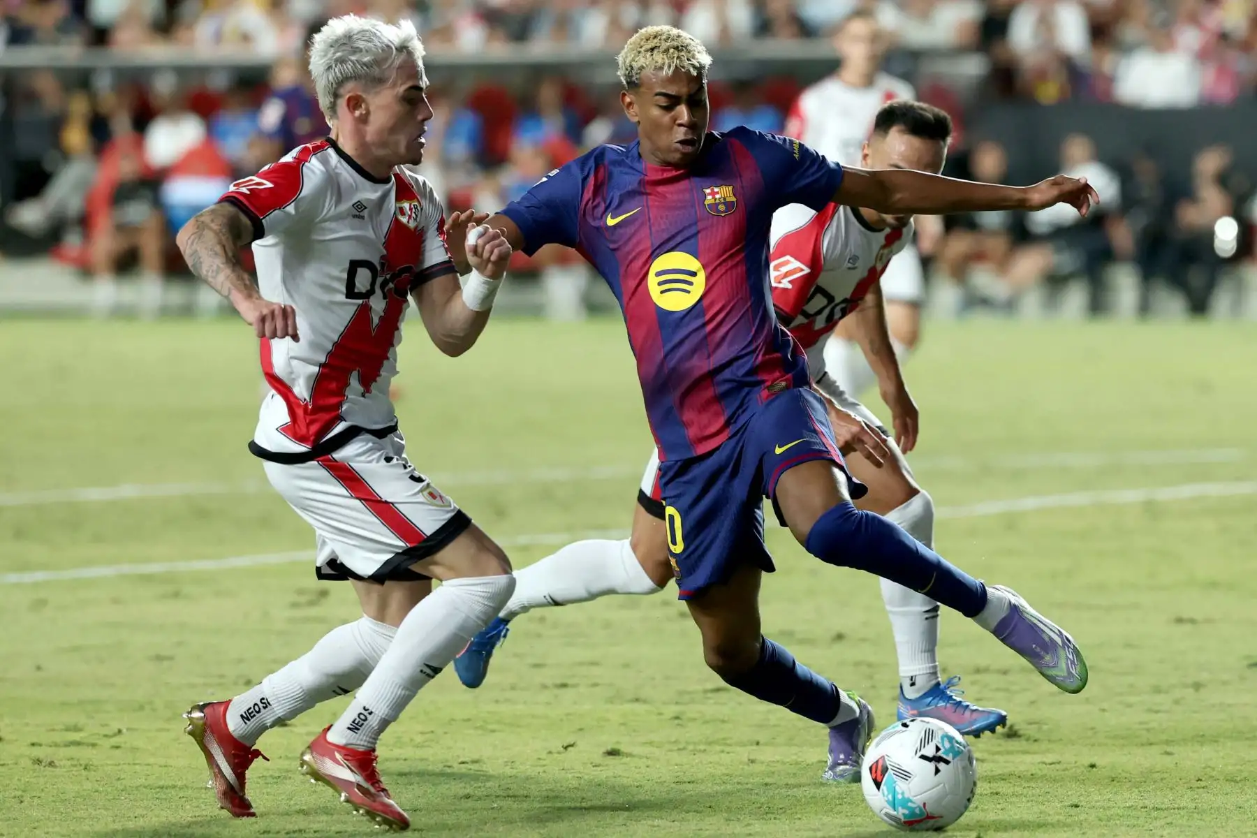 El delantero español del Barcelona, ​​Lamine Yamal, lucha por el balón con el defensa español  del Rayo Vallecano, Pep Chavarría, durante el partido de la liga española entre el Rayo Vallecano de Madrid y el FC Barcelona en el estadio de Vallecas en Madrid.
Foto: AFP