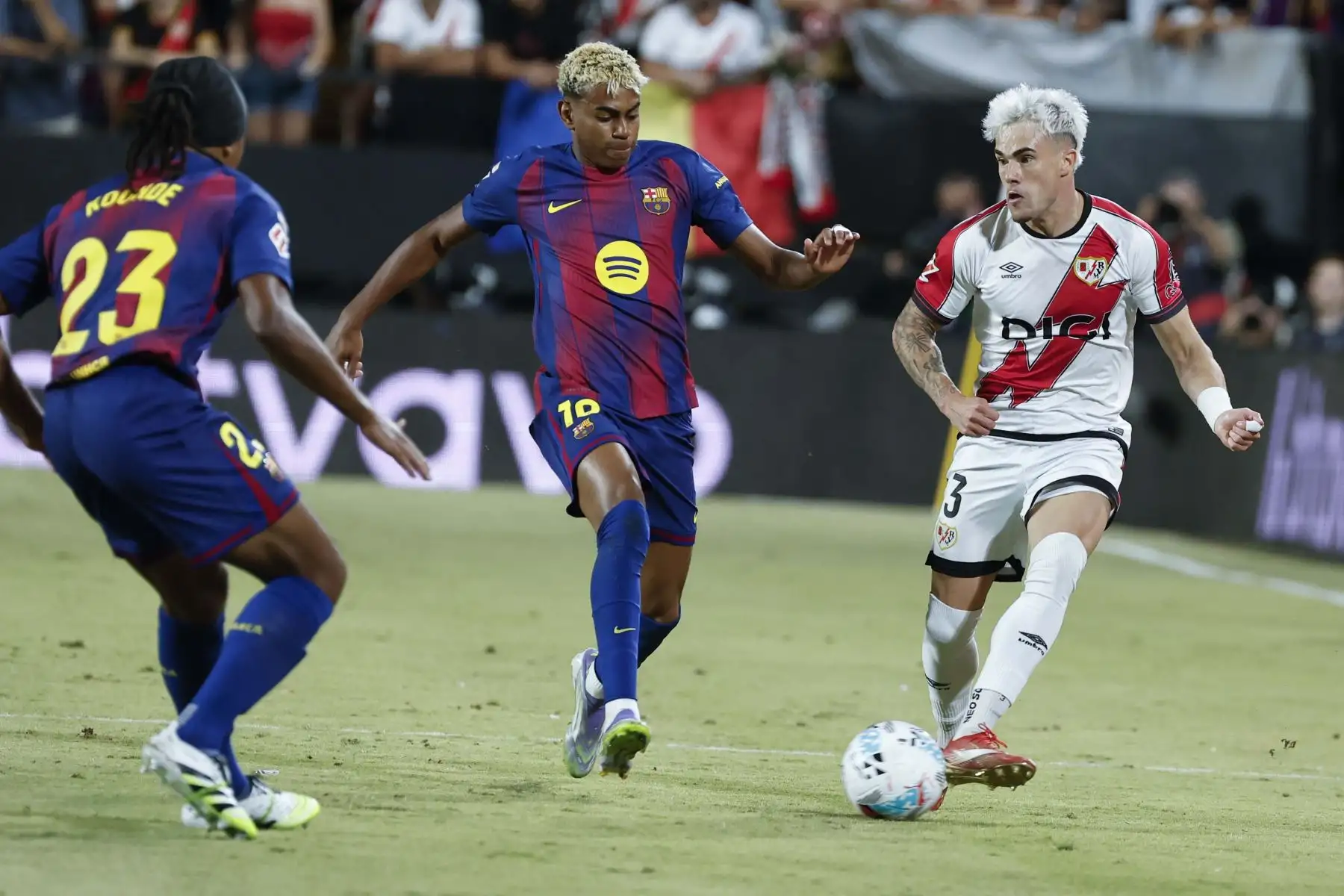 El defensa del Rayo Vallecano Josep Chavarría centra el balón junto a Lamine Yamal, del FC Barcelona, durante el partido de la tercera jornada de LaLiga entre el Rayo Vallecano y el FC Barcelona, este domingo en el estadio de Vallecas. 
Foto: EFE