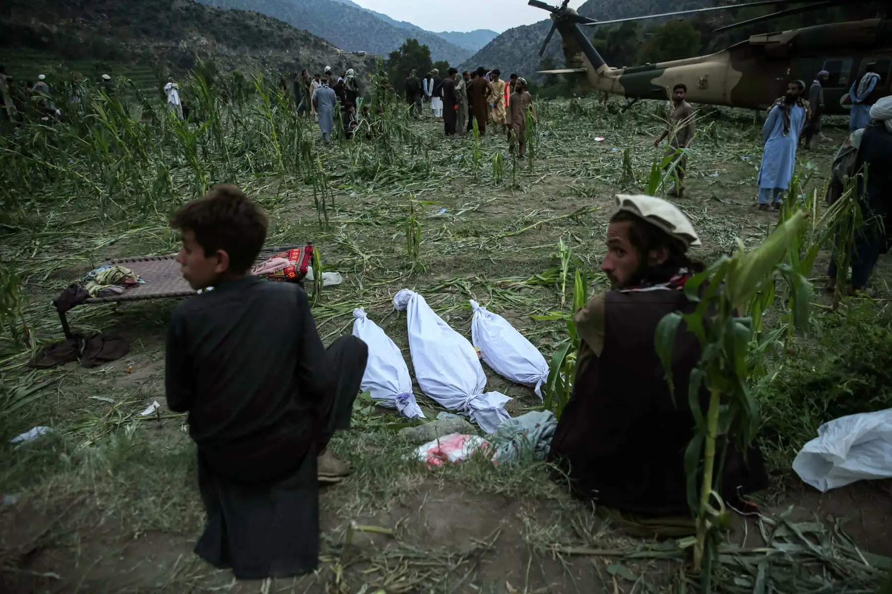 Afectados por un terremoto junto a los cuerpos de las víctimas en Kunar, Afganistán, el 1 de septiembre de 2025. Al menos 800 personas murieron y unas 2.000 resultaron heridas después de que un terremoto superficial de magnitud 6,0 ​. Foto: ANDINA/AFP