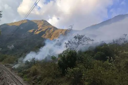 Combatientes monitorean el área principal del incendio, casi inaccesible, en el kilómetro 96.5 de la vía férrea hacia la ciudadela de Machu Picchu. ANDINA/Difusión