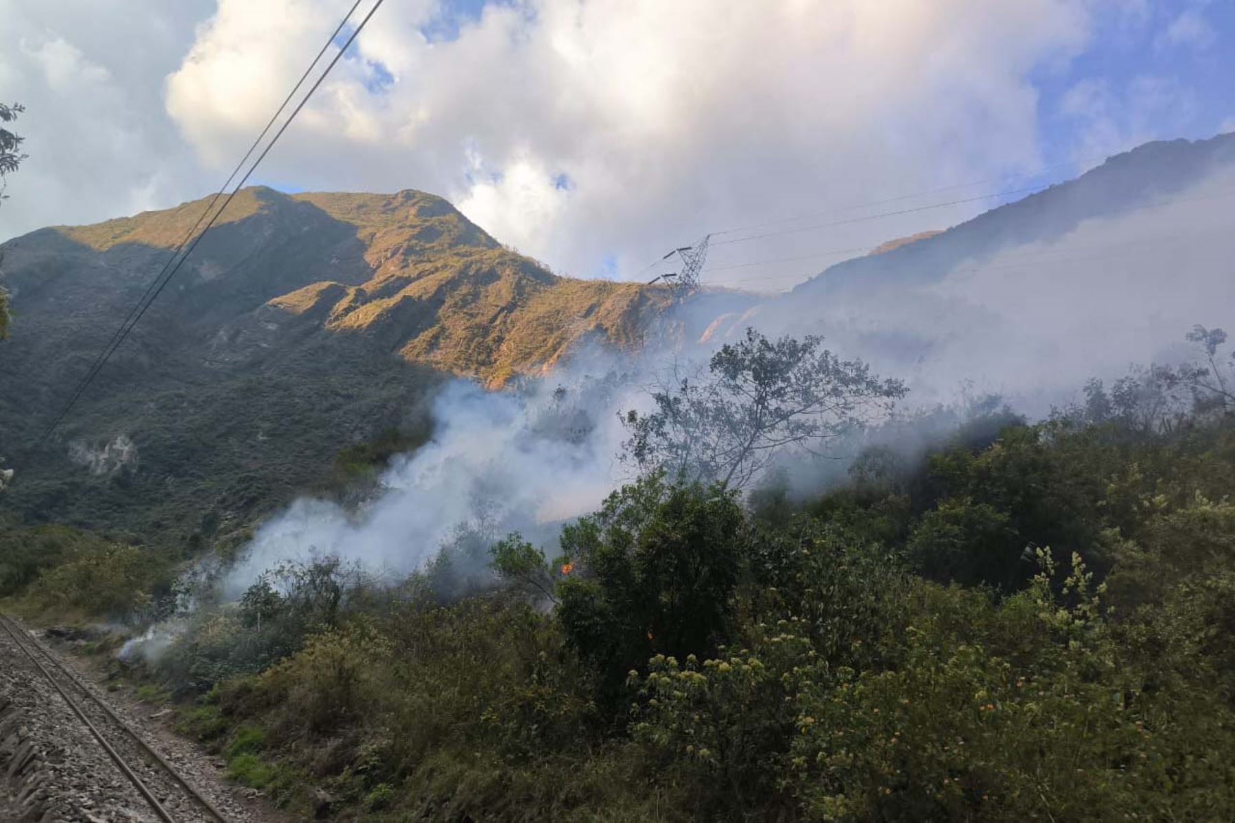 Combatientes monitorean el área principal del incendio, casi inaccesible, en el kilómetro 96.5 de la vía férrea hacia la ciudadela de Machu Picchu. ANDINA/Difusión