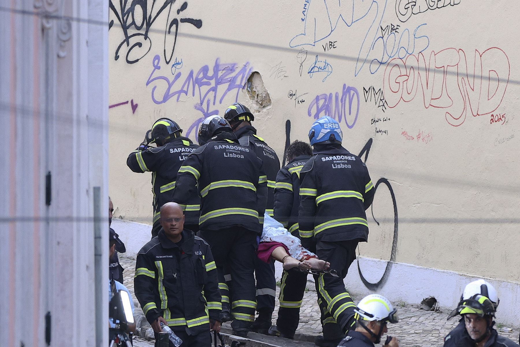 Rescatistas y bomberos trasladan a una víctima tras el descarrilamiento del funicular Gloria en Lisboa, Portugal.
Foto: EFE