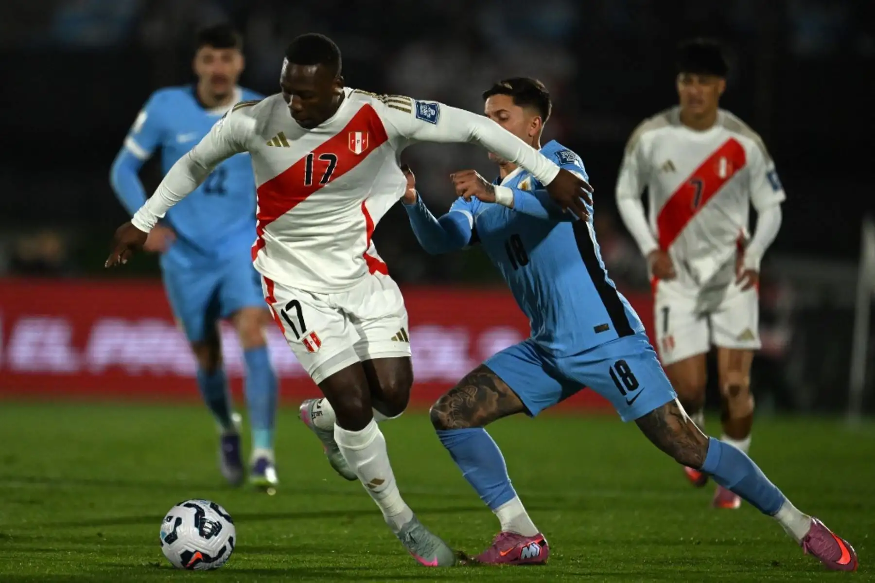 El defensor de Perú, Luis Advincula, y el defensor de Uruguay, Brian Rodríguez, luchan por el balón durante el partido de fútbol de las eliminatorias sudamericanas de la Copa Mundial de la FIFA 2026 entre Uruguay y Perú en el estadio Centenario de Montevideo el 4 de septiembre de 2025. Foto: AFP