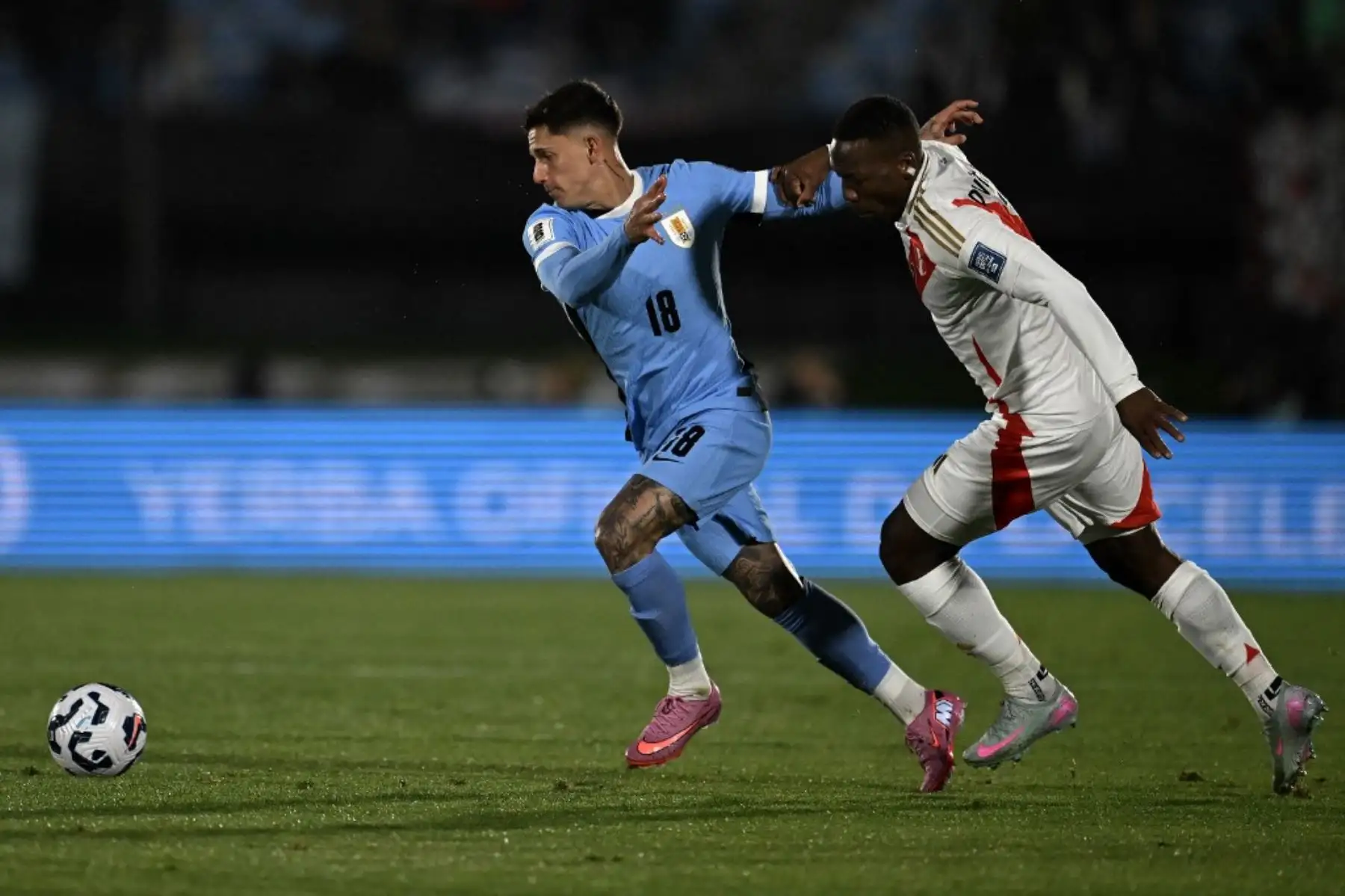 El defensor de Uruguay, Brian Rodríguez, y el defensor de Perú, Luis Advíncula, luchan por el balón durante el partido de fútbol de las eliminatorias sudamericanas de la Copa Mundial de la FIFA 2026 entre Uruguay y Perú en el estadio Centenario de Montevideo el 4 de septiembre de 2025. Foto: AFP