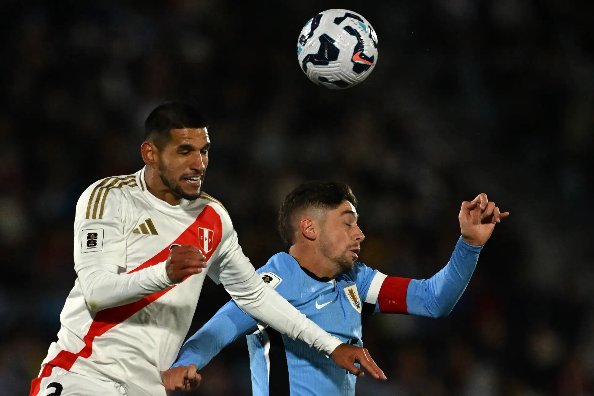 El defensor de Perú, Luis Abram, y el mediocampista de Uruguay, Federico Valverde, saltan para un cabezazo durante el partido de fútbol de las eliminatorias sudamericanas de la Copa Mundial de la FIFA 2026 entre Uruguay y Perú en el estadio Centenario en Montevideo el 4 de septiembre de 2025. Foto: AFP