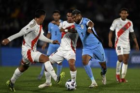 El delantero uruguayo Rodrigo Aguirre lucha por el balón con los defensas peruanos Marcos López y Erick Noriega. Foto: AFP