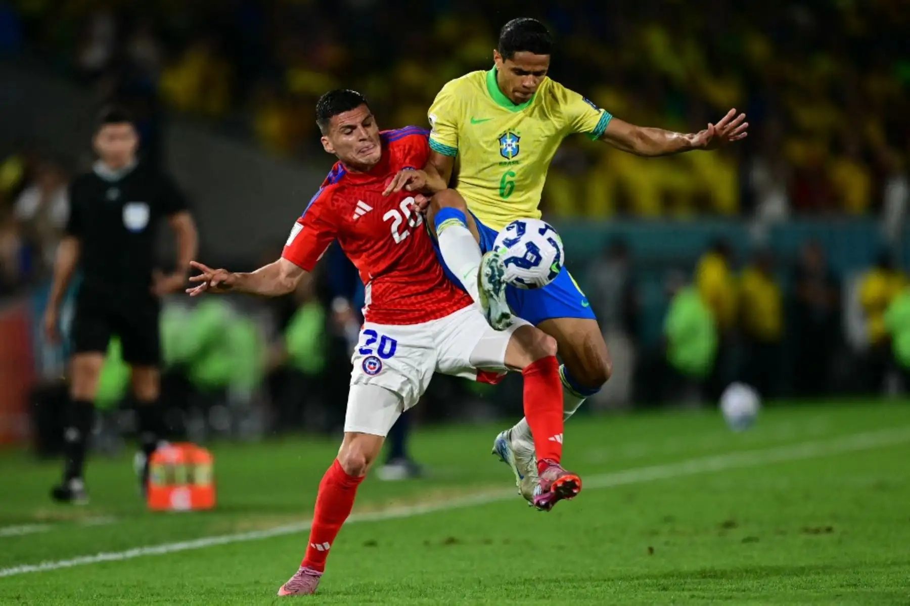 El delantero de Chile, Lucas Cepeda, y el defensor de Brasil, Douglas Santos, luchan por el balón durante el partido de fútbol de las eliminatorias sudamericanas de la Copa Mundial de la FIFA 2026 entre Brasil y Chile, en el estadio Maracaná en Río de Janeiro, Brasil, el 4 de septiembre de 2025. Foto: AFP