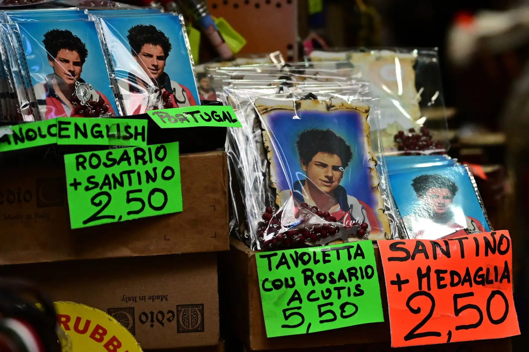 Imágenes del beato Carlo Acutis, un adolescente que dedicó su vida a difundir su fe en línea, lo que le valió el apodo de "Influencer de Dios", se imprimen en recuerdos en una tienda de Asís donde se exhibe Acutis.
Foto: AFP