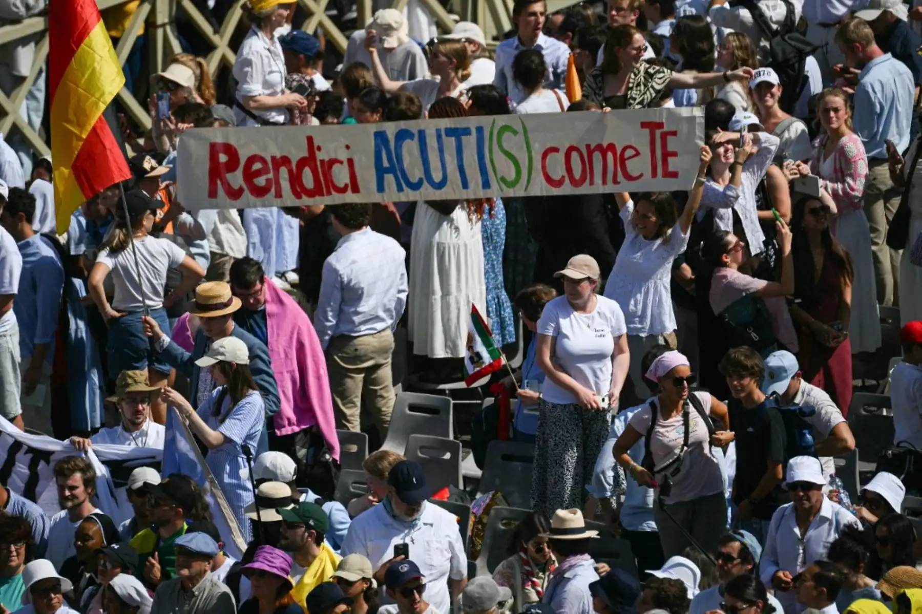 Fieles sostienen una pancarta con un juego de palabras sobre el nombre de Acutis: "Haznos tan astutos como tú" tras la Santa Misa y la canonización de los beatos Carlo Acutis y Pier Giorgio Frassati en la Plaza de San Pedro del Vaticano el 7 de septiembre de 2025. Foto: AFP