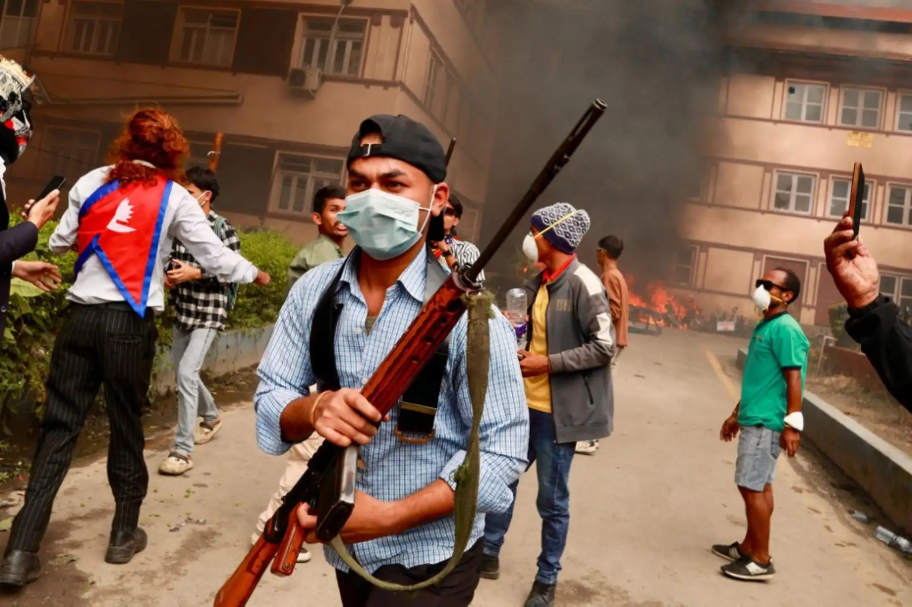 Manifestante empuña un arma de fuego mientras los manifestantes se congregan frente al complejo del palacio Singha Durbar durante una protesta en Katmandú. Foto: AFP