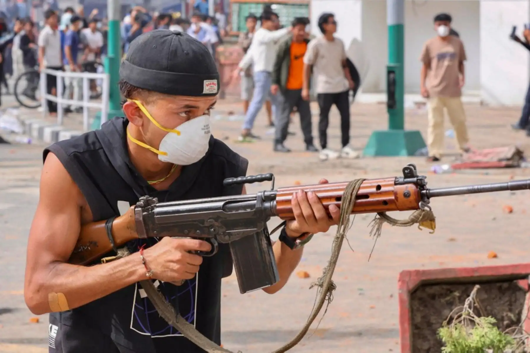 Manifestante empuña un arma de fuego mientras los manifestantes se congregan frente al complejo del palacio Singha Durbar durante una protesta en Katmandú. Foto: AFP