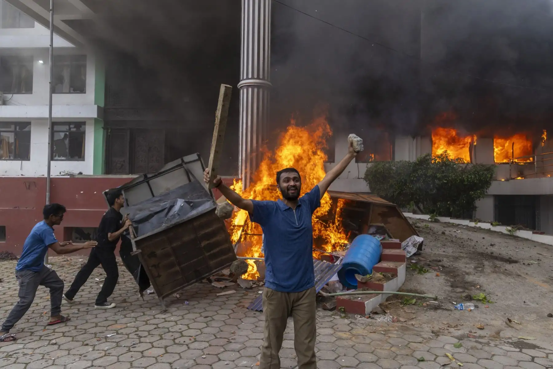 Manifestantes frente a la oficina del Partido del Congreso Nepalés, incendiada en Katmandú, Nepal. Foto: EFE