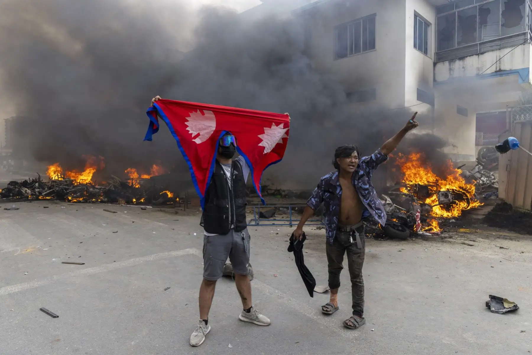 Un vehículo en llamas frente a la sede del Partido Comunista de Nepal fue incendiado en Katmandú, Nepal. Foto: EFE