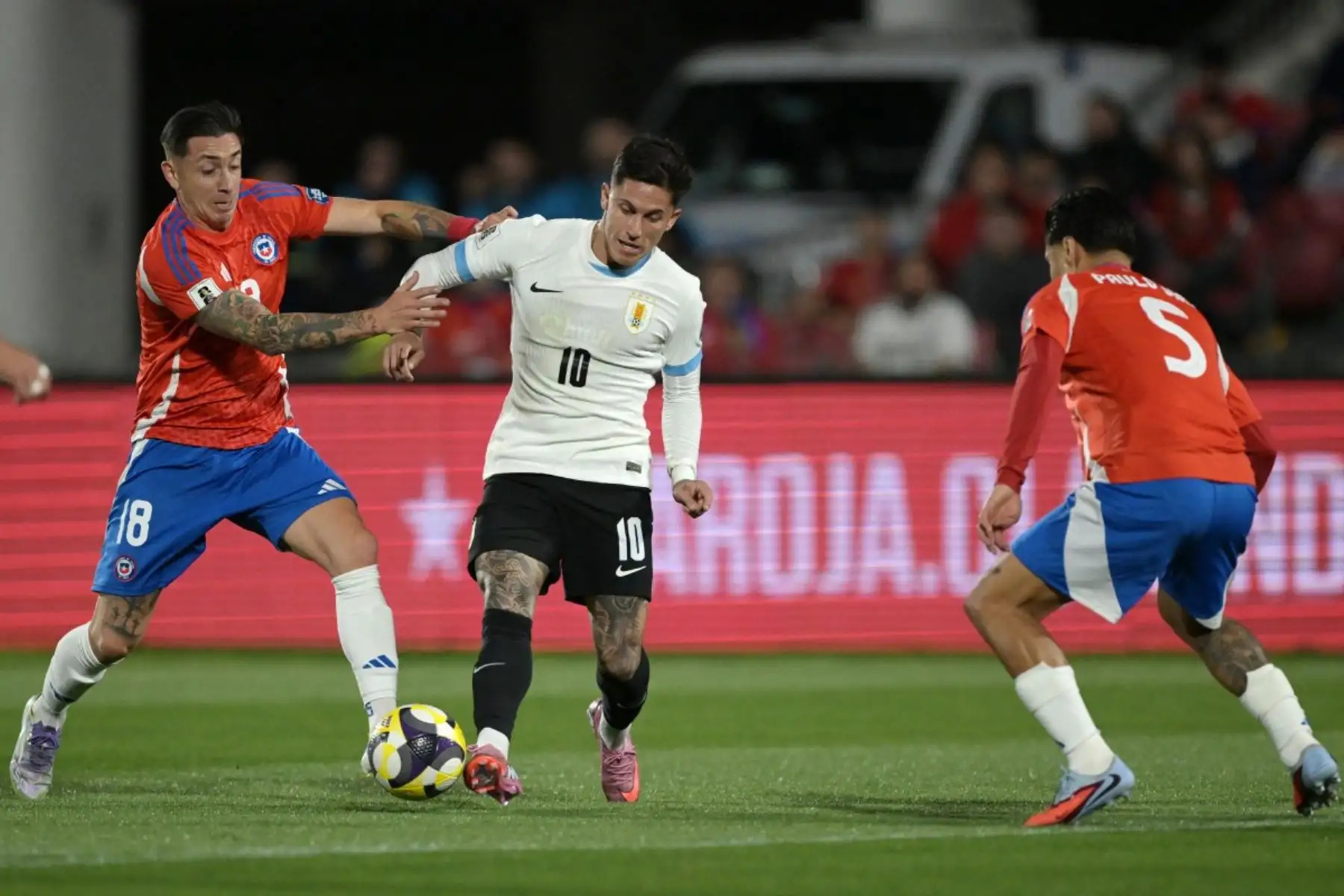 Chile empató 0-0 con Uruguay en el Estadio Monumental de Santiago, resultado que selló su eliminación de las Eliminatorias Sudamericanas rumbo al Mundial 2026. La Roja no logró revertir su irregular campaña y se despidió del torneo. En contraste, la Celeste aseguró su clasificación gracias a una sólida fase eliminatoria, confirmando su presencia en la próxima Copa del Mundo y ratificando el proceso exitoso de su plantel. Foto: AFP