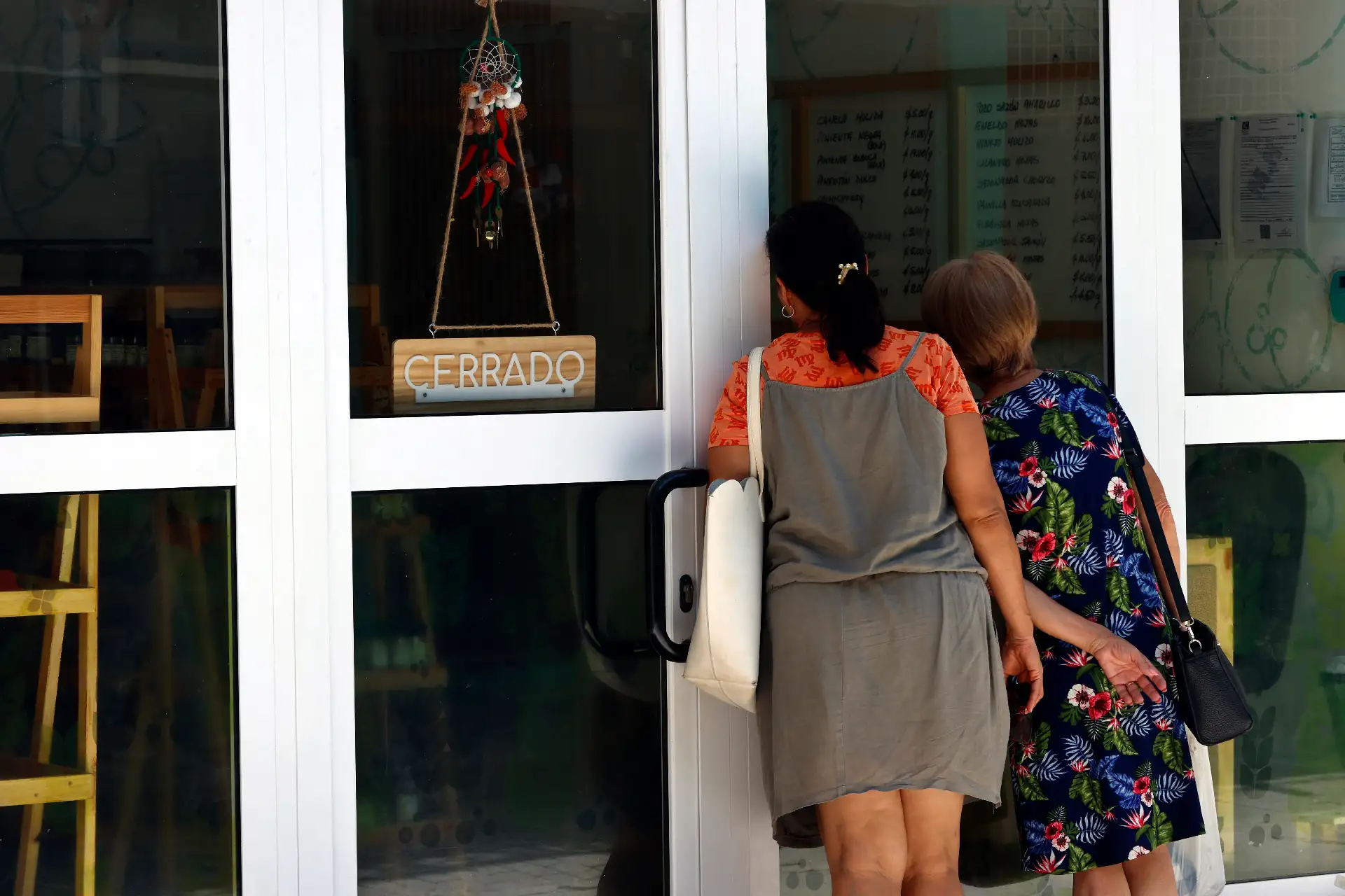 Personas observan el interior de un local cerrado por falta de electricidad este miércoles, en La Habana, Cuba. El Ministerio de Energía y Minas de Cuba informó que ha creado “microsistemas” que dan electricidad a centros considerados vitales como hospitales, en medio de las labores para restablecer el Sistema Eléctrico Nacional. Foto: EFE
