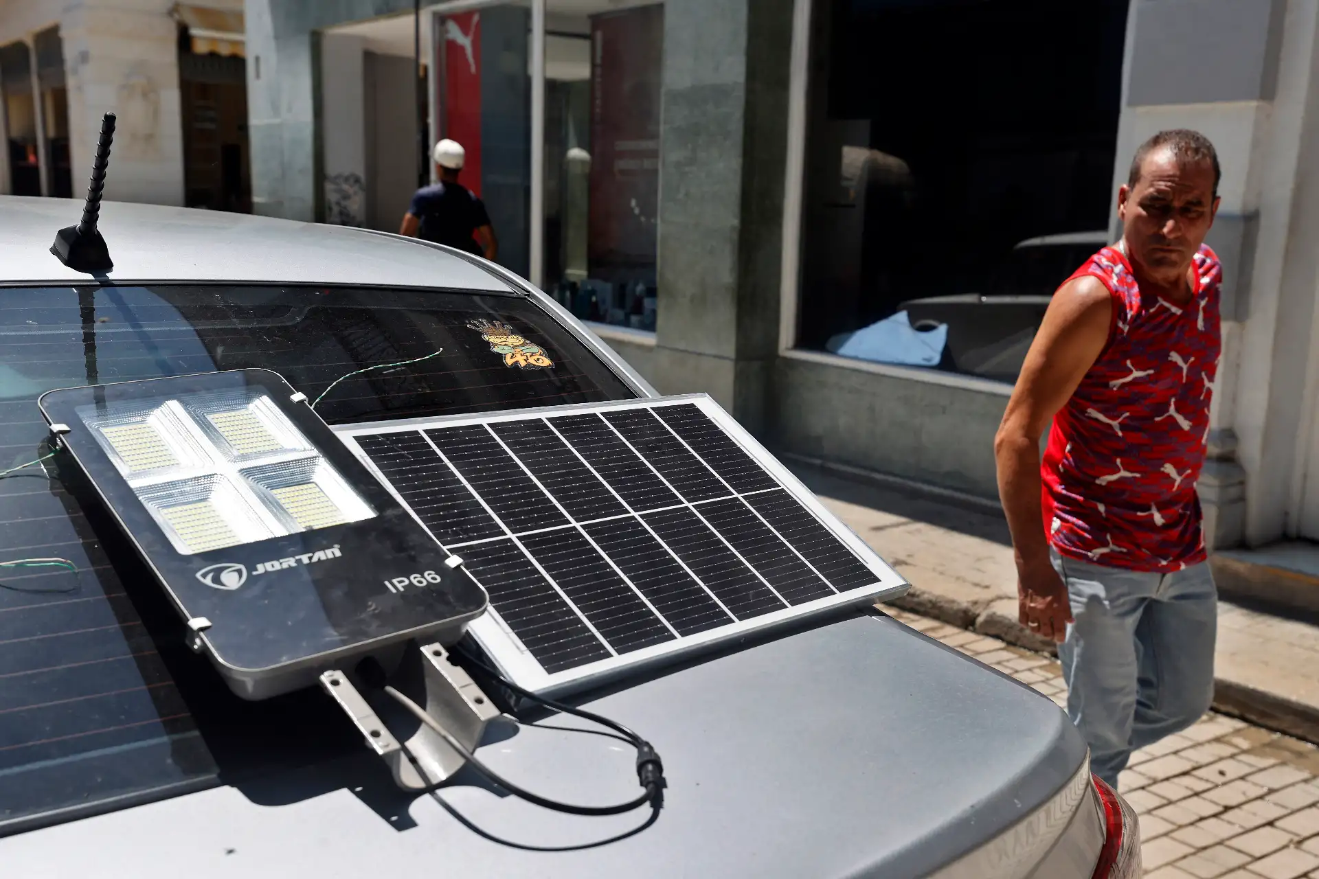Un hombre observa un panel solar suministrando energía a una lámpara este miércoles 10 de setiembre de 2025 en La Habana, Cuba, durante el apagón general en todo el país. Foto: EFE