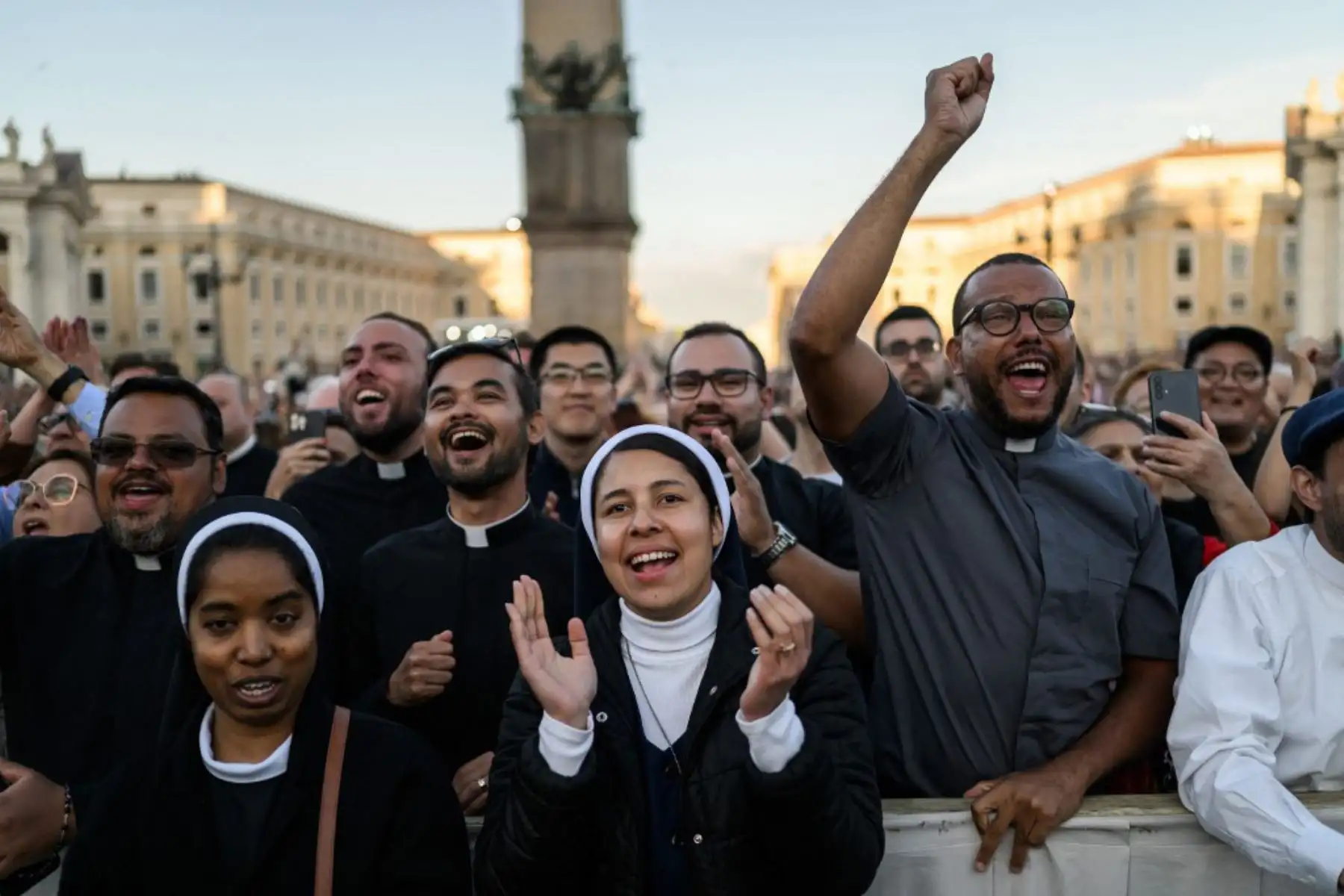 Miembros del clero reaccionan al ver al recién elegido Papa León XIV, Robert Prevost, aparecer por primera vez en el balcón central de la Basílica de San Pedro, tras la clausura del cónclave de los cardenales, en el Vaticano, el 8 de mayo de 2025. 
Foto: AFP