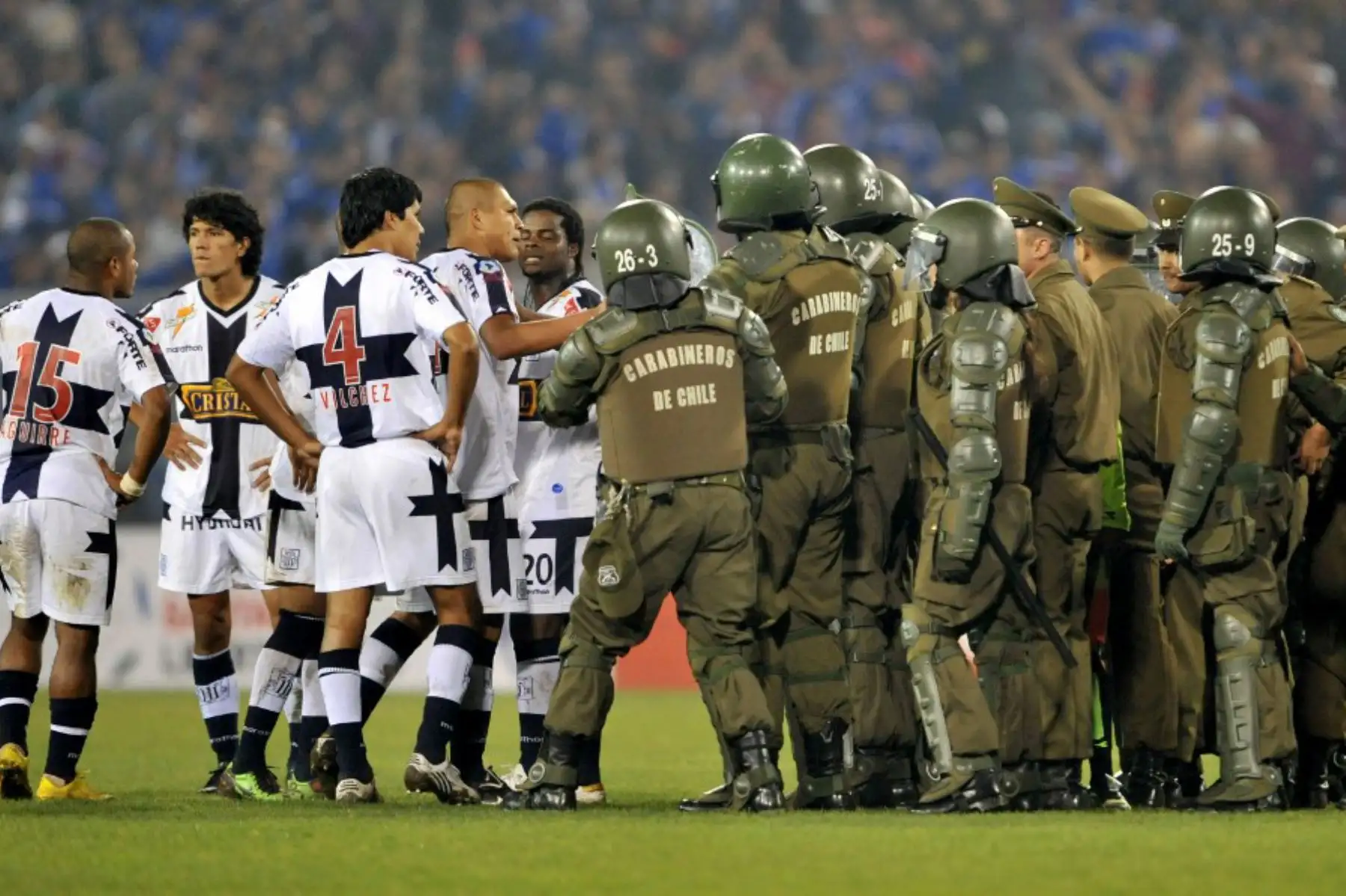 Jugadores del Alianza Lima de Perú discuten con la policía mientras protegen al árbitro Carlos Alfredo Vera durante los incidentes en el partido de la Copa Libertadores entre Alianza y la Universidad de Chile, el 6 de mayo de 2010. Foto: AFP