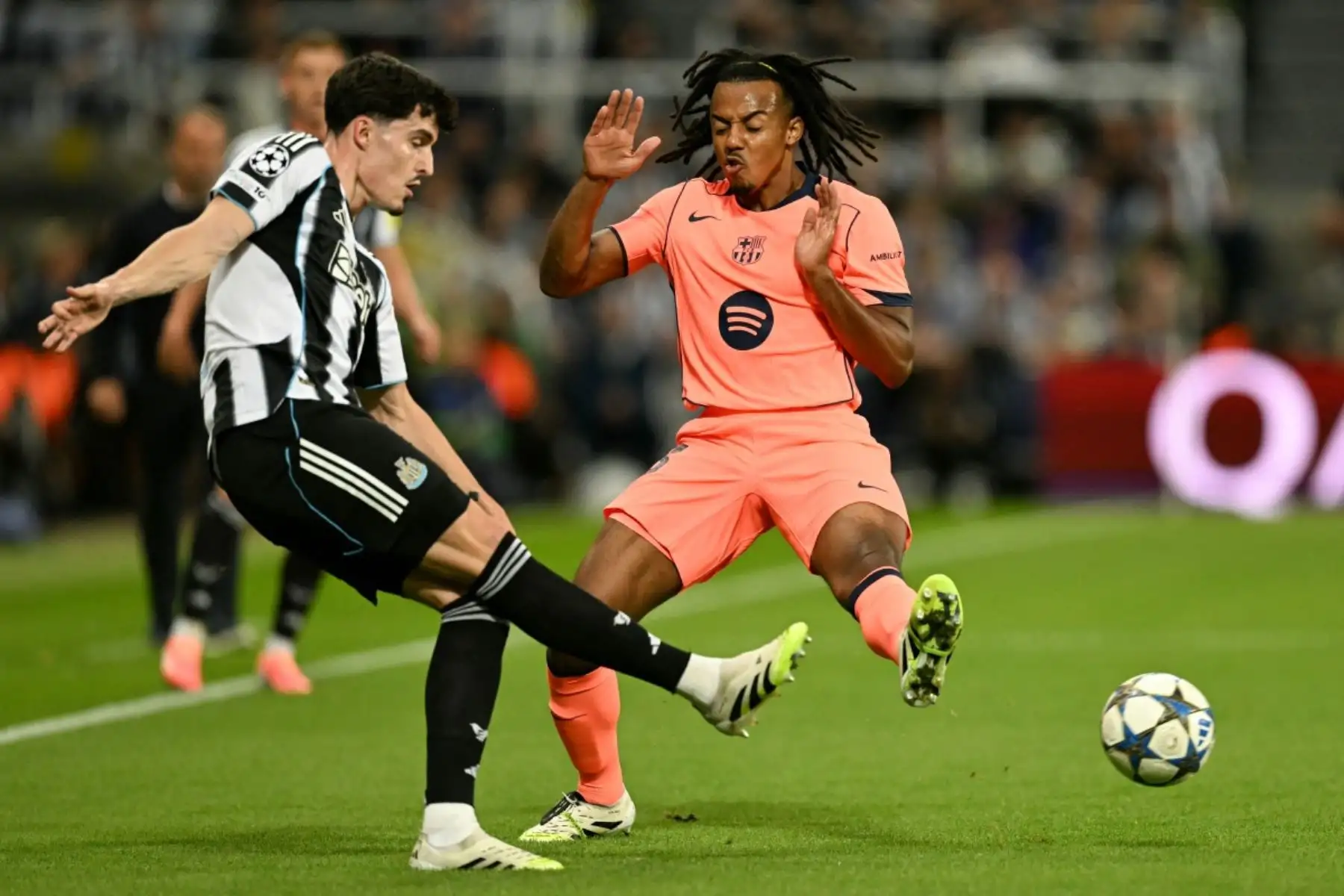 El defensa británico del Newcastle, Valentino Livramento, y el defensa francés del Barcelona, ​​Jules Kounde, luchan por el balón durante el partido de fútbol de primera ronda de la UEFA Champions League entre el Newcastle United FC y el FC Barcelona en St James