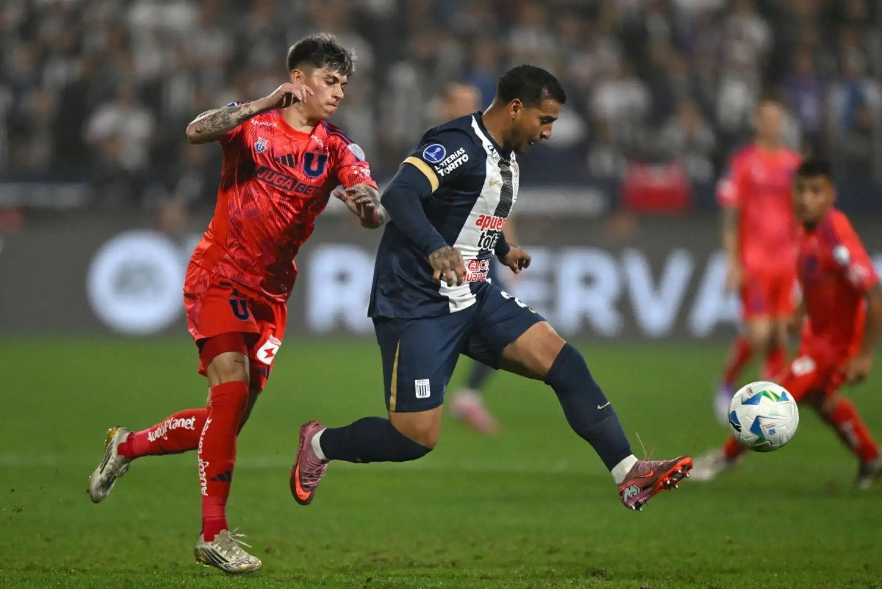 El delantero de la Universidad de Chile, Maximiliano Guerrero, y el mediocampista de Alianza Lima, Miguel Trauco, luchan por el balón durante el partido de ida de los cuartos de final de la Copa Sudamericana entre Alianza Lima y la Universidad de Chile en el Estadio Alejandro Villanueva. Foto: AFP