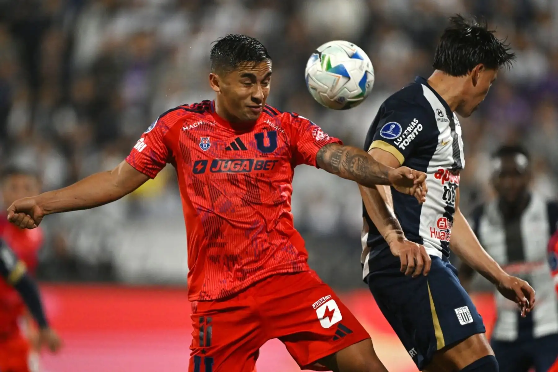 El delantero de la Universidad de Chile, Nicolás Guerra y el mediocampista ecuatoriano de Alianza Lima, Fernando Gaibor, luchan por el balón durante el partido de ida de los cuartos de final de la Copa Sudamericana entre Alianza Lima y la Universidad de Chile en el Estadio Alejandro Villanueva. Foto: AFP