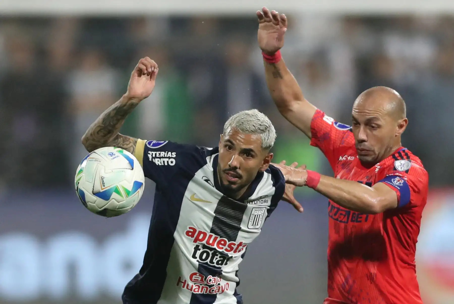 Sergio Peña de Alianza Lima disputa el balón con Marcelo Díaz de la Universidad de Chile este jueves en el partido de ida de cuartos de final de la Copa Sudamericana 2025 entre Alianza Lima y Universidad de Chile en el estadio Alejandro Villanueva en Lima. Foto: EFE