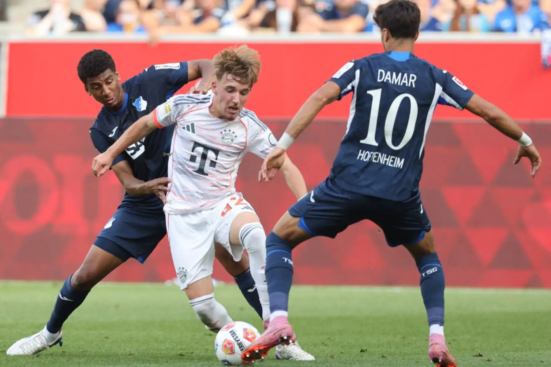 El centrocampista alemán del Bayern Munich, Lennart Karl, y el centrocampista alemán del Hoffenheim, Muhammed Damarvie, luchan por el balón durante el partido de fútbol de la primera división alemana Bundesliga entre TSG 1899 Hoffenheim y FC Bayern Munich en Sinsheim, suroeste de Alemania. Foto: AFP