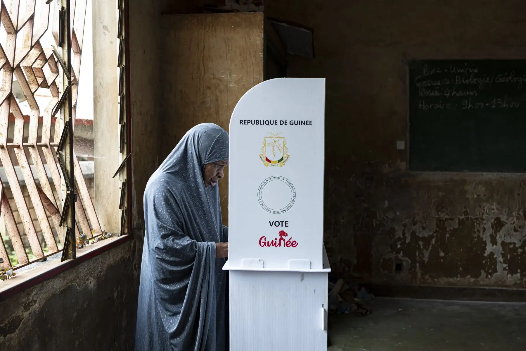 Una votante marca su papeleta tras una cabina de votación en el colegio electoral de la escuela primaria Hamdallaye en Conakry, mientras Guinea vota en el referéndum constitucional. Cuatro años después de la toma del poder por los militares, los guineanos finalmente votan sobre un nuevo proyecto de constitución que allanaría el camino para las elecciones. Foto: AFP