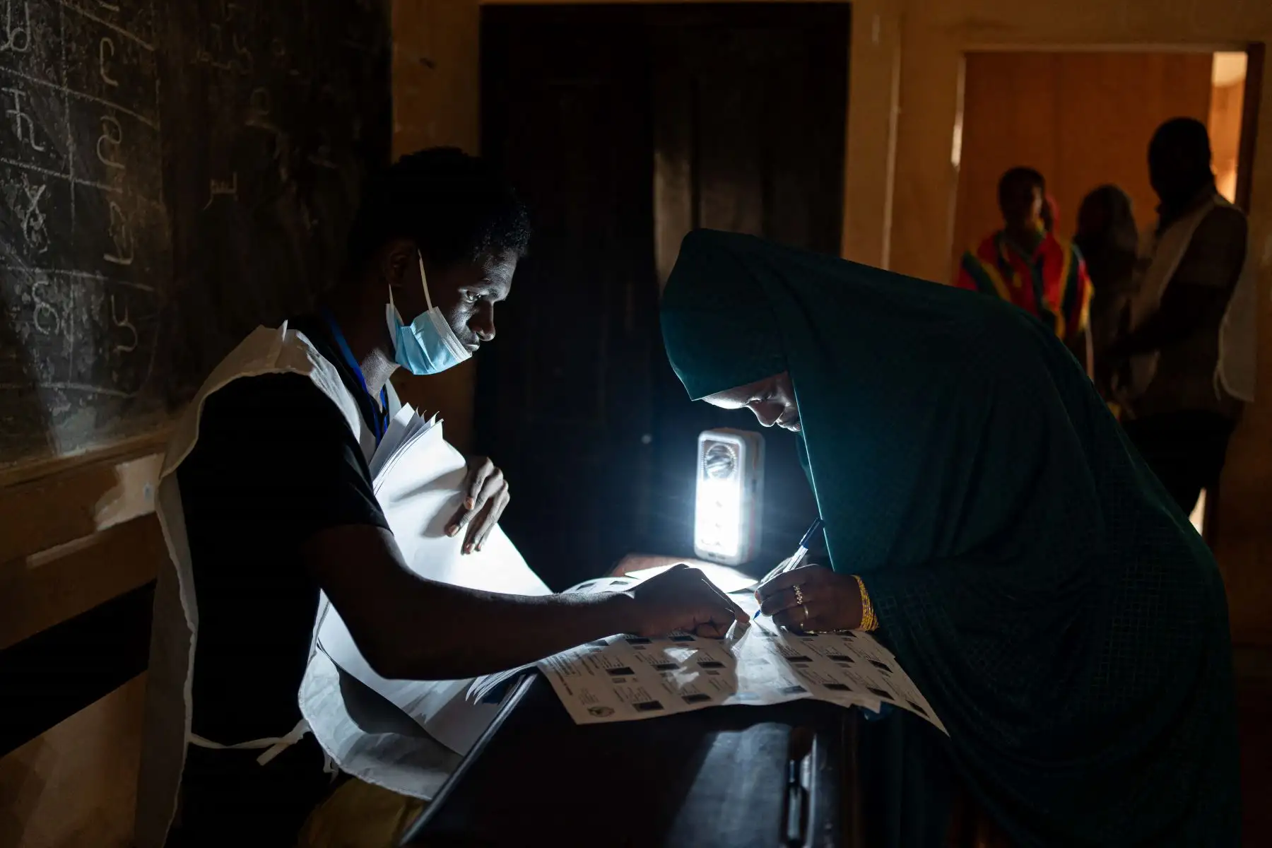 Una funcionaria de la Dirección General de Elecciones de Guinea revisa el censo electoral en el colegio electoral Housseine Center, ubicado en una escuela de Conakry, el 21 de septiembre de 2025, mientras el país entero vota en el referéndum constitucional que allanaría el camino hacia nuevas elecciones. Foto: AFP